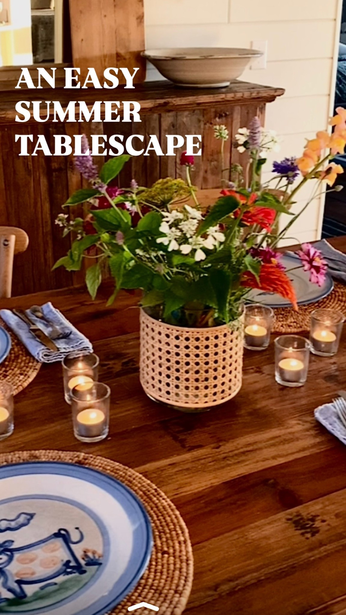 Looking for simple summer table inspiration? This cozy cottage-inspired tablescape combines fresh flowers, candlelight, woven textures, and charming blue-and-white dishes to create a welcoming setting for effortless entertaining. Save this idea for your next summer dinner party, brunch, or family gathering!