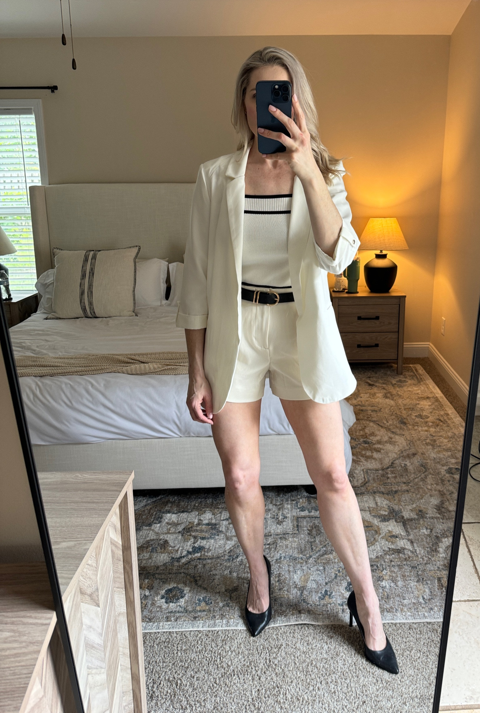 Trouser shorts, white knit tank, white blazer, black belt and black heels 