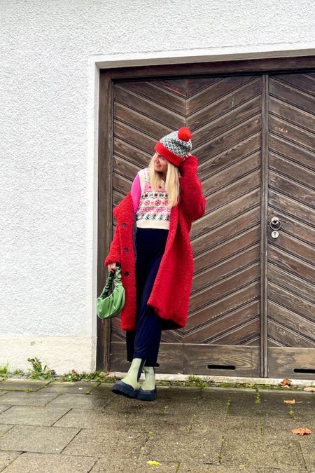 Red Teddy Coat. Fashion Blogger Girl by Style Blog Heartfelt Hunt. Girl with blond hair wearing a red teddy coat, Christmas beanie, pink top, Christmas vest, black pants, green ruched bag and green chunky boots. #colorfuloutfit #colorfulstyle #colorfulfashion #colorfullooks #fashionfun #cutefalloutfit #fallfashion2022 #falllookbook #fitcheck #dailylooks #dailylookbook #contentcreator #microinfluencer #discoverunder20k