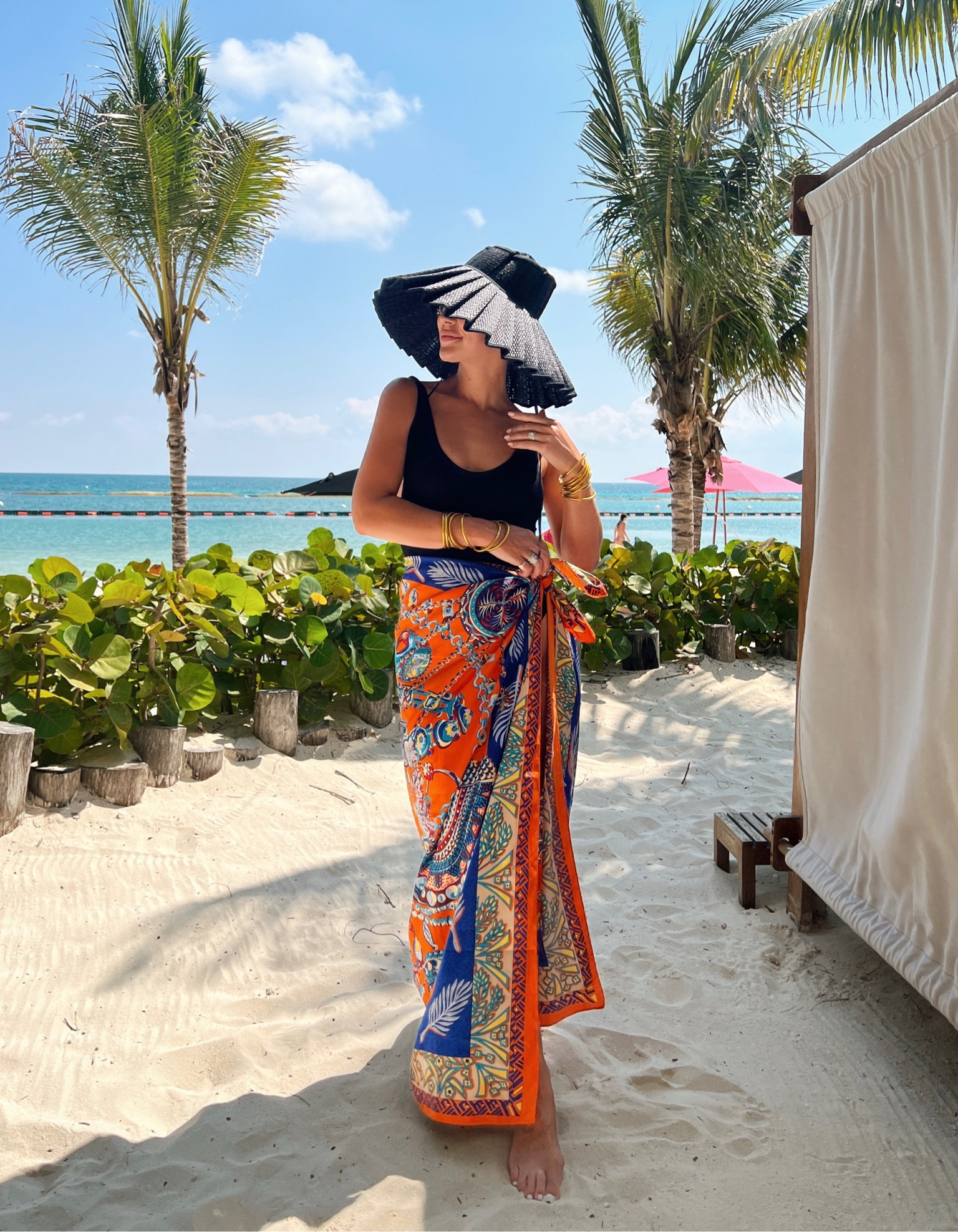 Black one piece swimsuit, black pleated straw hat, orange sarong, beach look

#LTKswim #LTKtravel