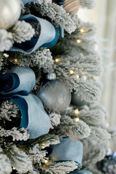 Gorgeous blue Christmas tree idea for breaking out of the traditional look. Simply add some blue and silver ornaments to a flocked tree. Finish with blue ribbon, picks, and a silver tree topper. Add a blue or beau teal tree skirt for a final touch.

#LTKhome #LTKSeasonal #LTKHoliday