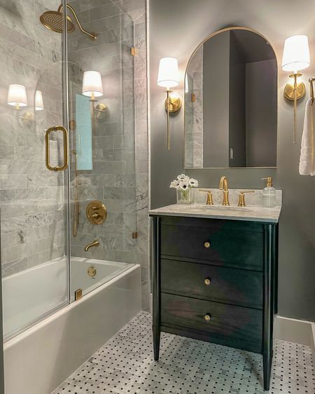 Moody classic hallway bathroom decor and finishes! This black bathroom vanity is stunning! Perfect for a smaller space. All these brushed gold finishes match almost perfectly!

Paint color: Cityscape by SW
Tile: Carrara Marble from Floor & Decor (linked similar basket weave flooring)

#LTKsalealert #LTKstyletip #LTKhome