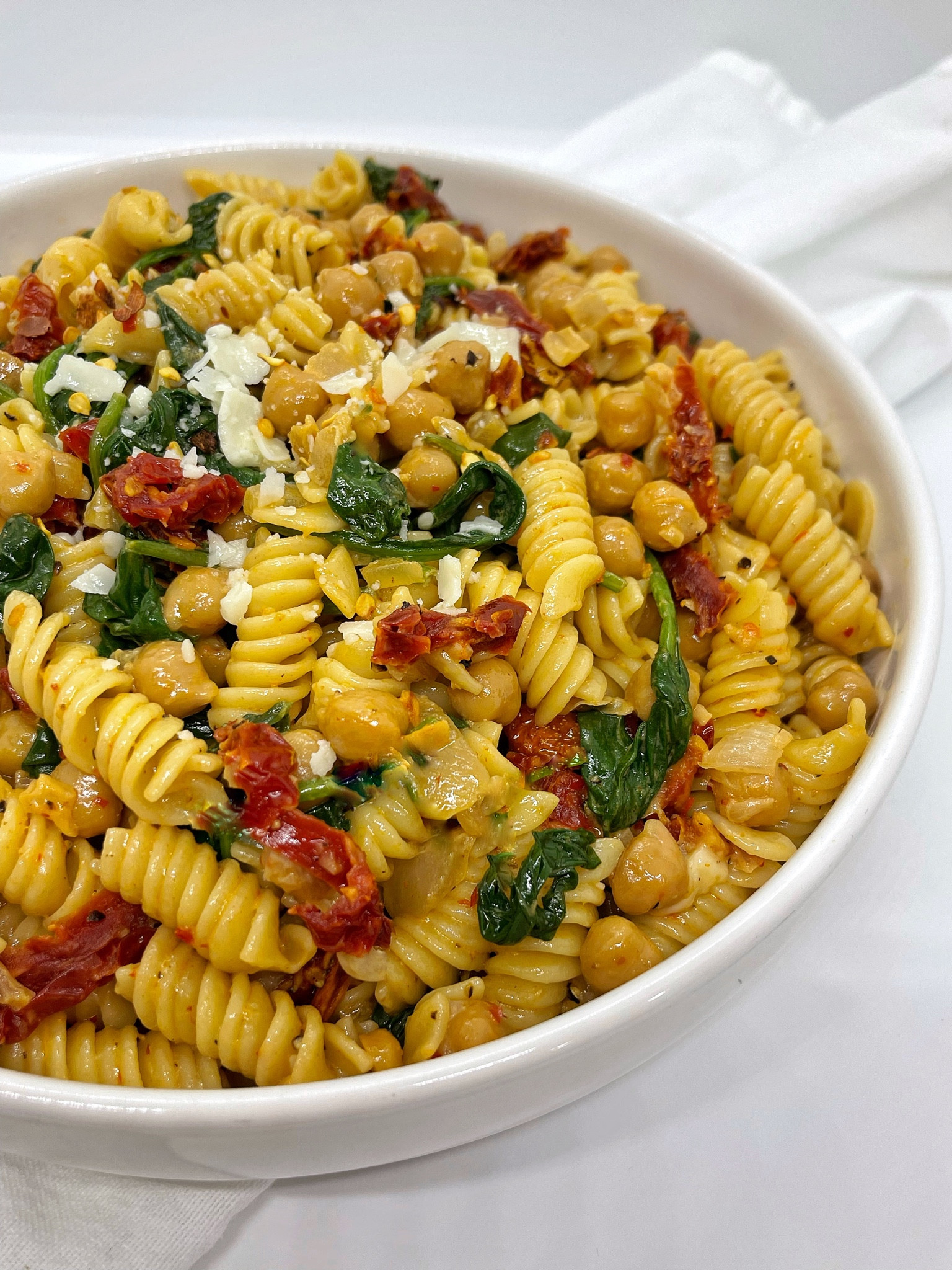 •SPICY HIGH PROTEIN PASTA• ready in 20, packed with protein and can be made as spicy (or not spicy) as you want. 🔥 

INGREDIENTS 
2 boxes of @eatbanza rotini pasta 
Olive oil
1 large white onion, diced
8-10 garlic cloves, minced 
Salt, cracked pepper -to taste 
1 can chickpeas, drained 
3 cups spinach 
1 cup sun-dried tomatoes, sliced 
1 cup heavy cream
1 cup grated parmesan cheese, plus extra for topping
2 tbsps @traderjoes Harissa paste (add less or more depending on your spicy tolerance) 

DIRECTIONS 
1. Cook pasta according to package instructions. 
2. Add olive oil, onions, garlic, salt and pepper to a large pot on medium heat. Sauté for 3-4 minutes. 
3. Add chickpeas. Sauté for 3-4 minutes. 
4. Add spinach, sun-dried tomatoes, pasta and olive oil. Gently mix. 
5. Add heavy cream, cheese, salt, pepper and harissa paste. Gently mix. 
6. Top with more cheese before serving. 

White bowls, recipes, pots and pans, wooden spoons, kitchen utensils, pasta, quick recipes

#LTKhome #LTKFitness #LTKunder50