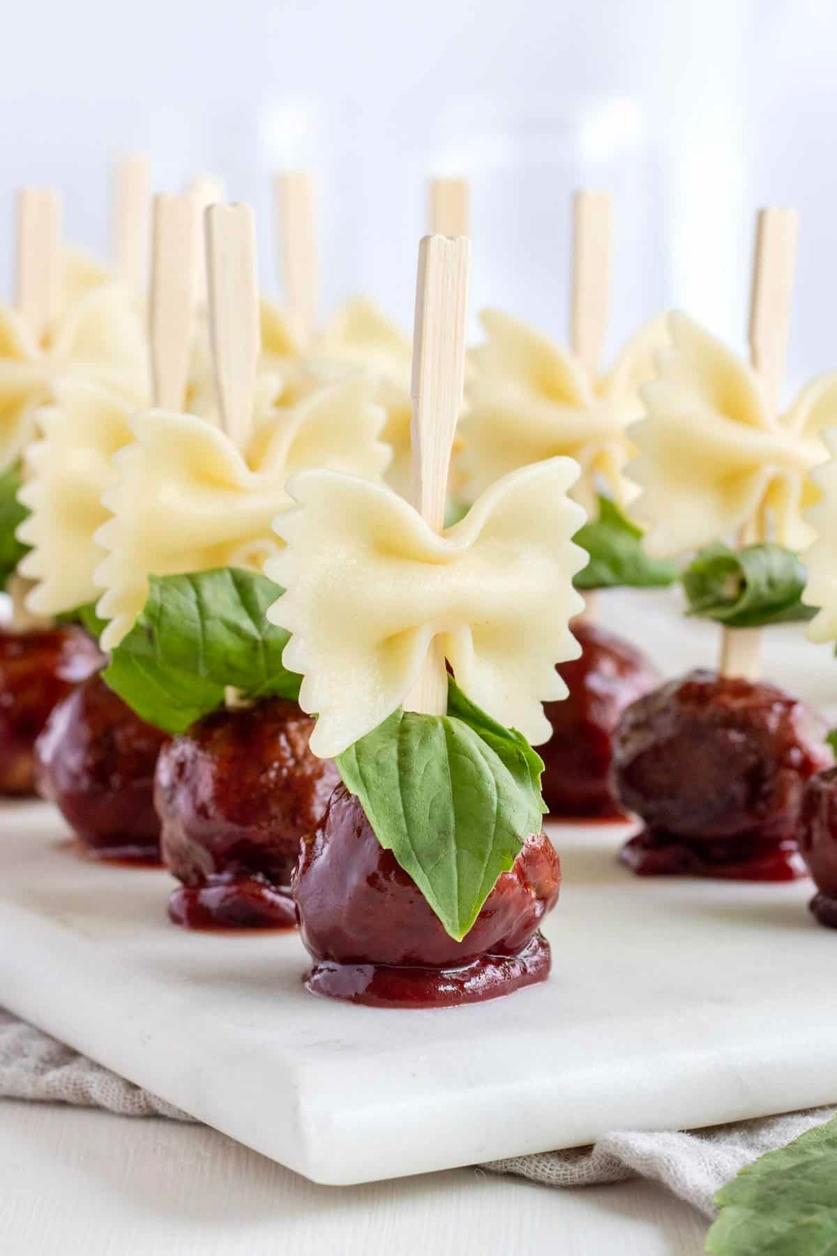 Add deliciousness and charm to your soiree with these Bowtie Pasta and Cocktail Meatball Skewers. Savory, saucy meatballs, al dente pasta and sweet, fresh basil make these appetizers an instant hit.

#LTKfoodie #LTKHoliday