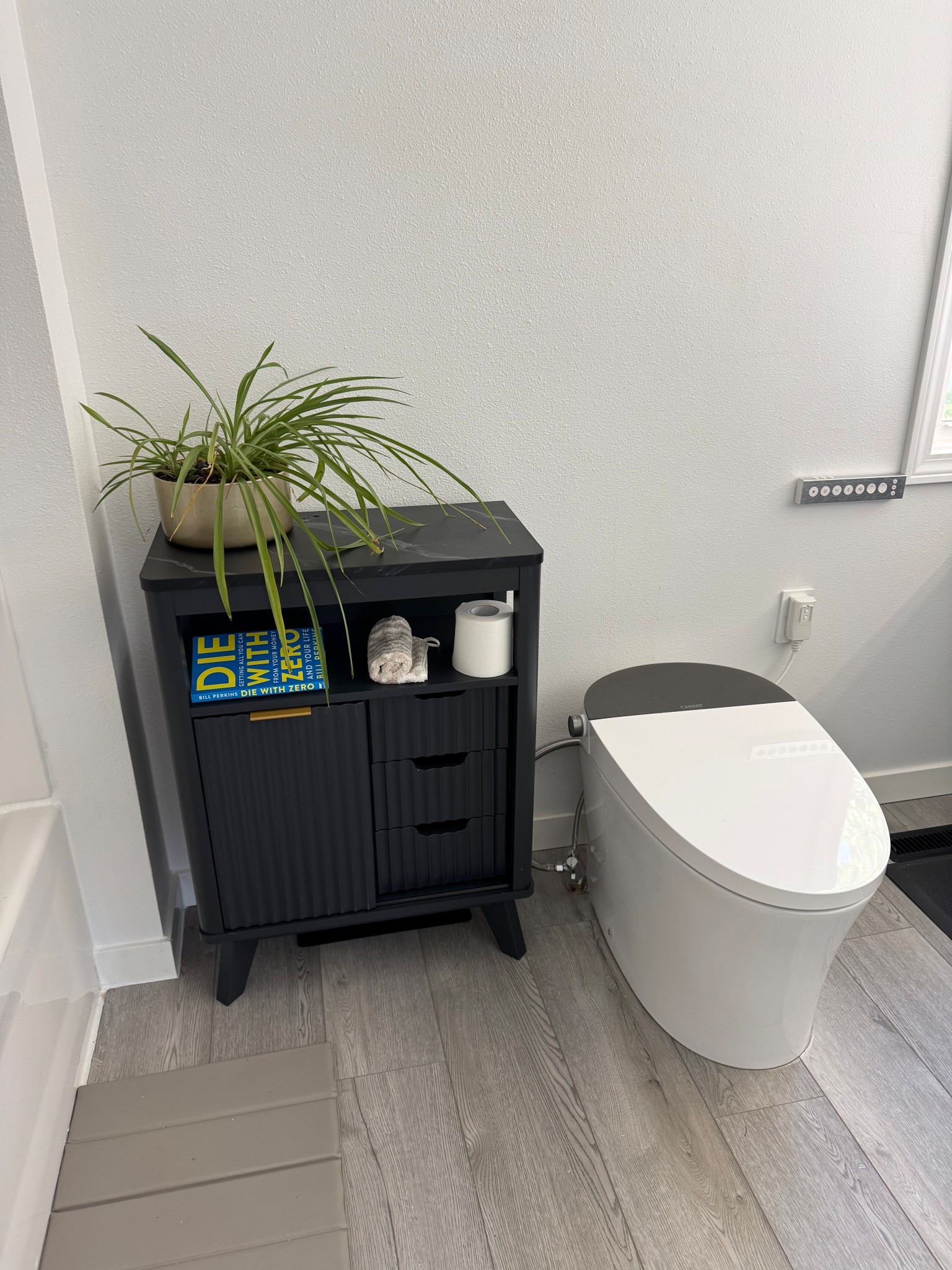 Bathroom goals: minimal, modern, and functional.
Our bathroom setup features a sleek black storage cabinet that hides all the not-so-pretty necessities while keeping the essentials (like a good book and extra TP) within reach.
We paired it with a smart toilet—because once you go bidet, you don’t go back—and topped it off with a spider plant for that touch of green.

Shop the look below! 🖤🪴🚽

#BathroomGoals #HomeVibes #MinimalistHome #BathroomOrganization #SmartToiletLife #DieWithZero #LTKHome #AmazonFinds #BathroomDecor #BidetLife

#LTKHome
