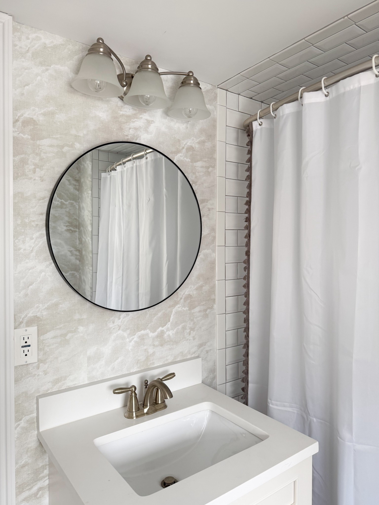 This bathroom mix feels like such an easy way to combine classic and modern elements in one space. The round mirror adds a clean, simple shape, while the brushed metal fixtures and lighting bring in that timeless finish that works with everything. Paired with the soft patterned wallpaper and crisp tile, it creates a look that feels fresh but still grounded.

Attic bathroom, bathroom remodel, bathroom mirror ideas, round mirror bathroom, brushed nickel fixtures, bathroom lighting ideas, neutral bathroom design, modern classic bathroom, subway tile bathroom, bathroom wallpaper ideas, small bathroom inspiration, clean bathroom aesthetic, bathroom refresh ideas girlonthehudson

#LTKHome #LTKMothersDay #LTKSeasonal