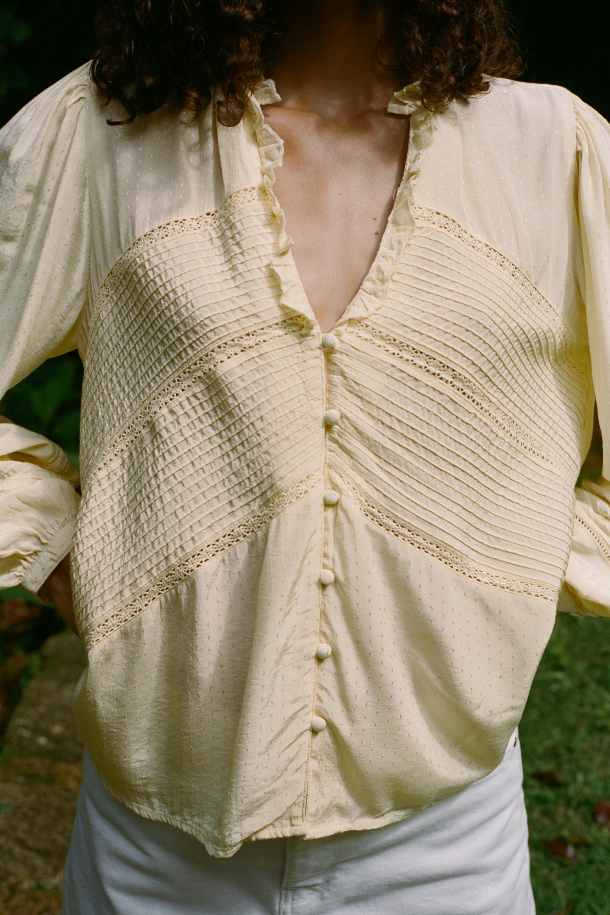 V-neck blouse with ruffle and long sleeves. Tonal pintuck and lace trim detail. Front closure wit... | Zara US