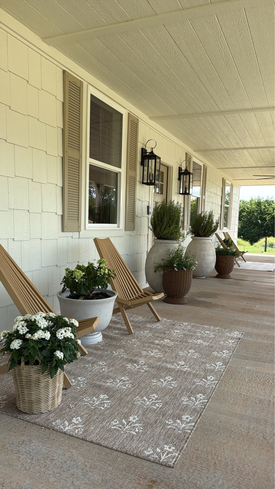 Flip house front porch. These 5x7 outdoor rugs are affordable but I also went into my local store and they were on clearance for $50 each. The basket planter on the bottom left is from ikea and has a plastic insert to plant in. It says “last chance” so grab one now if you like it! Other planters are Walmart and the huge ones are Ballard designs and I have linked them! I also super love these outdoor exterior lantern lights that are a great size! Under $100 each too! From @lowes

#LTKHome #LTKSeasonal