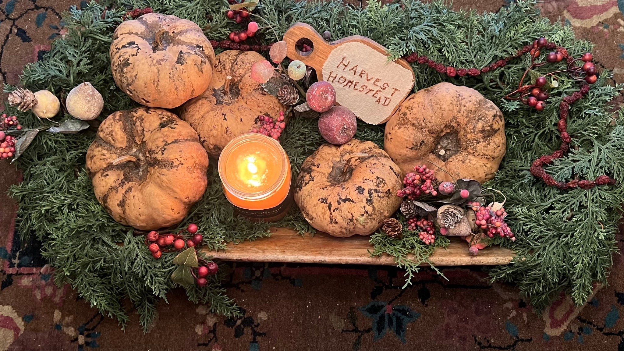 Turn any large container into a centerpiece. Here we’ve used an antique wooden trencher, filled it with dried gourds, greenery and a candle for a perfect touch! 
www.sugarcreekantiques.com
#LTKHoliday 

#LTKHome #LTKSeasonal