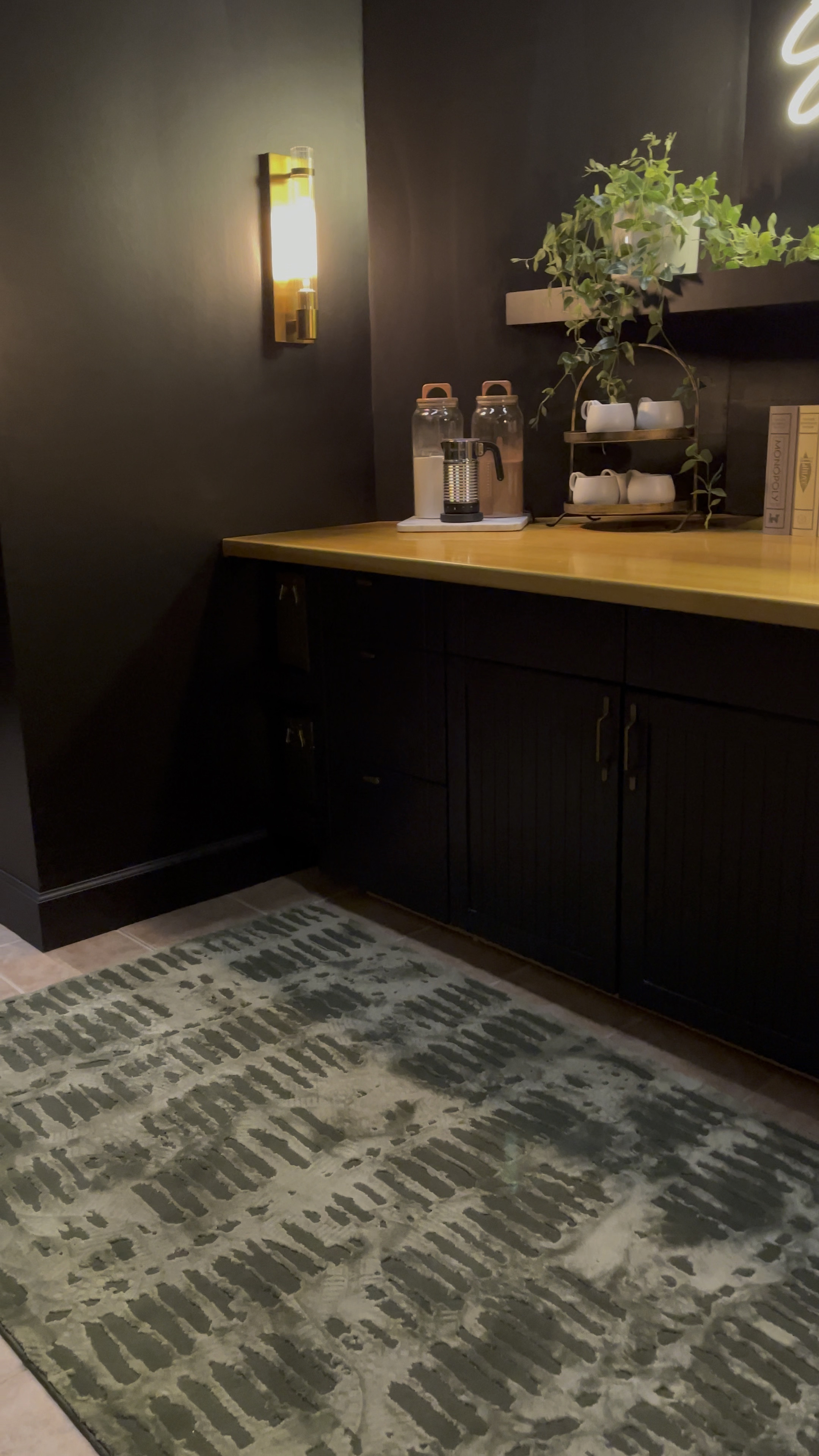 Revival Rugs vibrant green rug adds a splash of color to this sleek, all-black arcade room with a stylish snack bar. The playful yet sophisticated geometric pattern perfectly complements the style in the room, creating an inviting and visually captivating space.

#LTKhome #LTKFind #LTKfamily