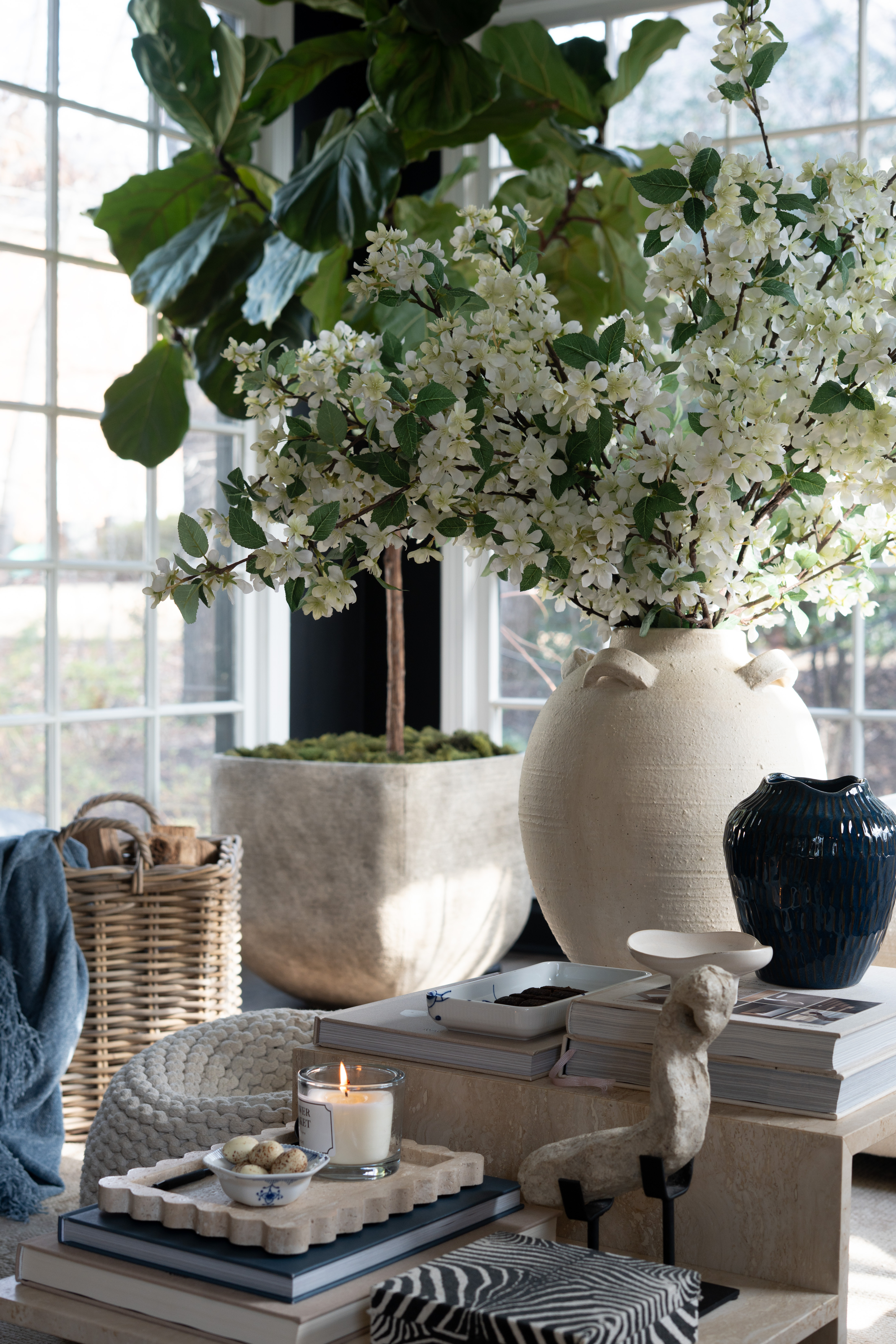 I love when a space feels both calm and elevated at the same time. The oversized ceramic vase, spring blossoms, stacked design books, candlelight, and layered neutral textures create the perfect cozy living room moment. 

 #LTKSpringSale #LTKSeasonal #LTKSaleAlert
