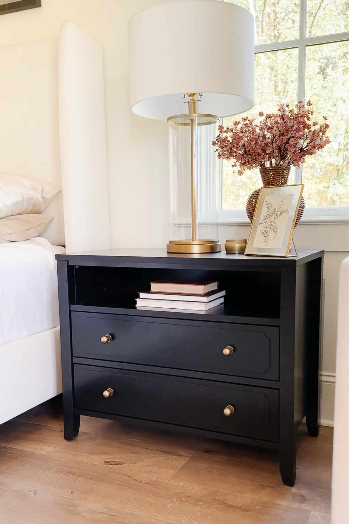 My nightstands are currently on sale at Wayfair for the lowest price I’ve seen in a while! 🙌 I customized mine by swapping out the single center ring pull for two side ball knobs, and it made such a difference in the look. Here’s how I did it:

1️⃣ Filled the center hole with Kwikwood epoxy putty (apply from the back and gently smooth it as flush as possible to the front of the drawer face without getting any on the drawer face which would require sanding. Sanding would take the sheen off the drawer face so avoid this. Kwikwood doesn’t shrink like typical hardware fillers do this will help it stay flush. 
2️⃣ Color the putty once it is hardened. You can use a black wood marker that I linked below (what my friend Mel @coryell.home did) did with great success) or leftover black paint—Sherwin Williams Tricorn Black in satin sheen—which is what I did. It may take more than 1 coat allowing it to dry between coats. 
3️⃣ New holes were drilled 5 1/2” from the edge of the drawer and centered on the height of the drawer face  

#LTKHome #LTKSaleAlert