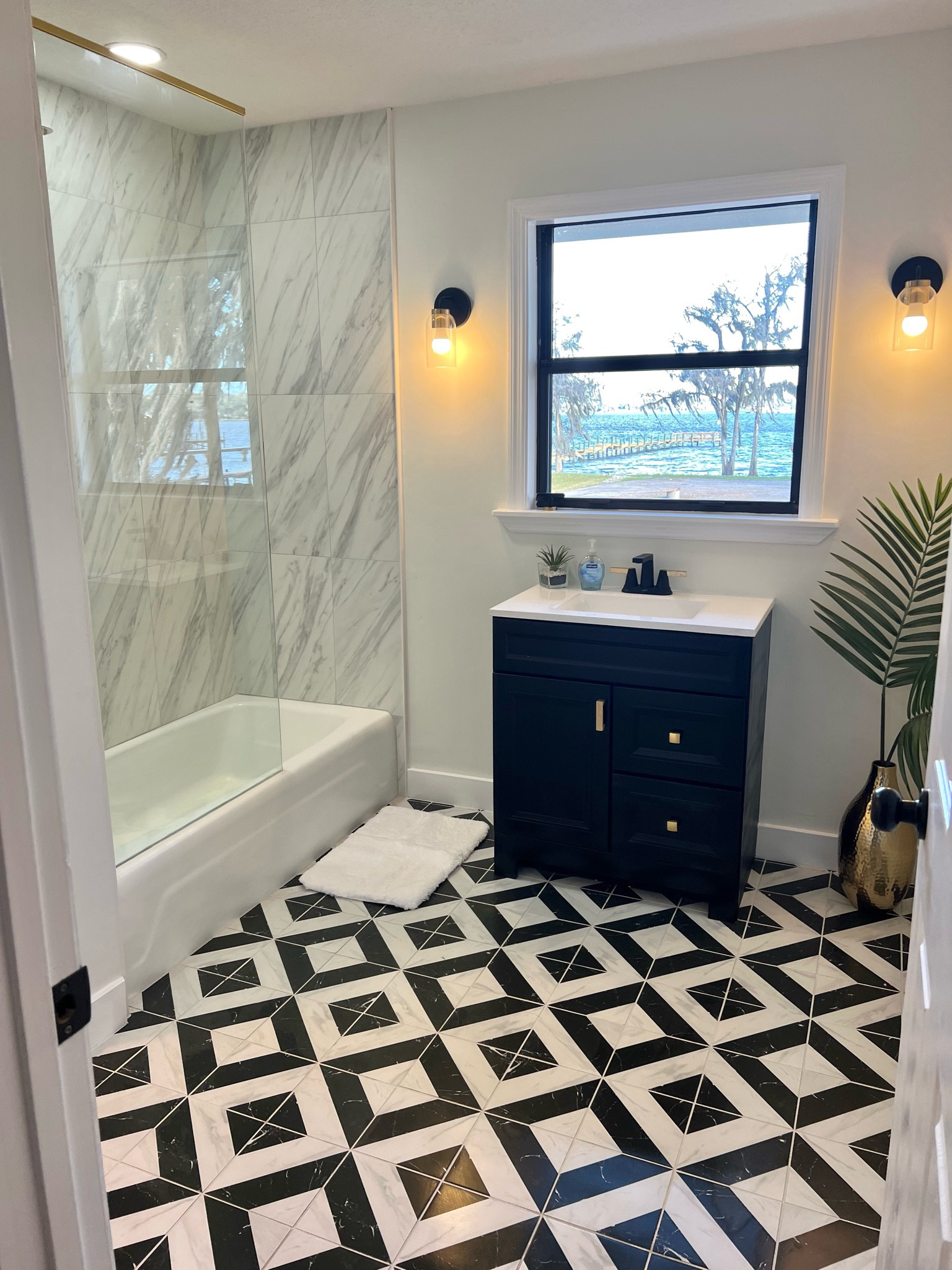 Still have some things to finish up (decor wise) in this bathroom but the bulk of it is finished. I had a vision for this space & love how it turned out. Linked what I could. Bathroom vanity was white and I changed out the hardware & had it painted. I love the high gloss black finish. 

Tile floor is Adessi Cesari (floor & decor) Shower wall is also floor & decor Cesari Bianca II Polished Porcelain 

#LTKsalealert #LTKhome #LTKFind