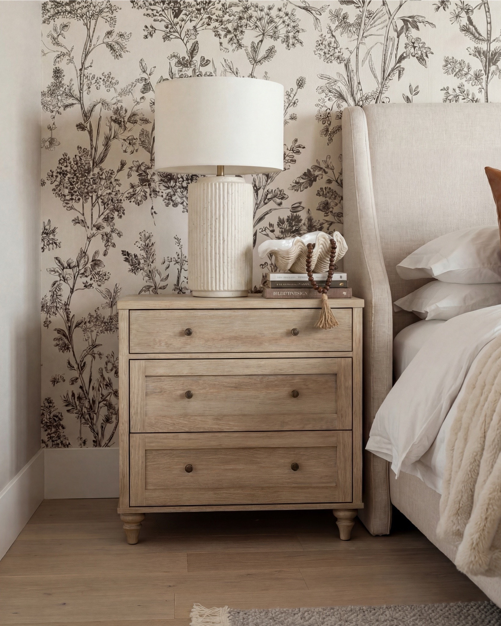 Bedroom Refresh : Shop The Look.
This bedroom is the perfect blend of calm neutrals and rich warmth. The tonal floral wallpaper does so much of the heavy lifting here—it adds depth without overpowering, creating that soft, romantic backdrop every cozy bedroom dreams of.

The caramel leather pillows are the star moment. They bring in warmth, contrast, and that elevated “quiet luxury” touch that instantly makes the space feel more intentional. Paired with the creamy upholstered bed and ribbed bench, the textures just flow.

Between the light wood nightstands, the sculptural lamps, and the warm beams above, this room is all about layers—neutral, organic, and timeless. It’s simple, but in the most curated way.

Shop the Look:
• Cream upholstered bed
• Caramel leather throw pillows
• Beige floral wallpaper
• Light wood nightstands
• Textured ceramic bedside lamps
• Ribbed upholstered end-of-bed bench
• Soft neutral area rug
• Brown plush throw blanket

#LTKsale #LTKhome #LTKstyletip