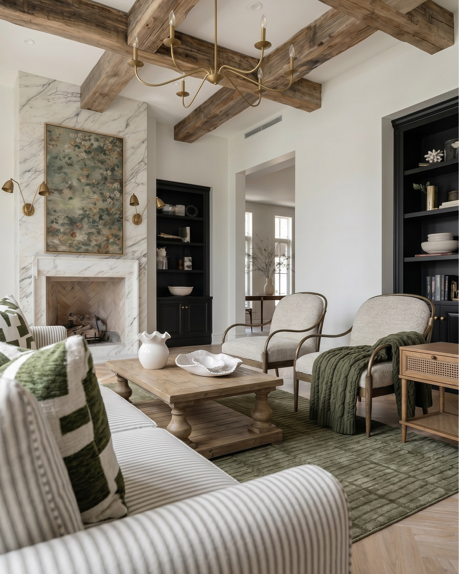 Shop the look:
* Slipcovered striped sofa (neutral performance fabric)
* Curved wood accent chairs with upholstered cushions
* Rustic wood coffee table (turned leg design)
* Mid-century style wood side tables with cane shelving
* Green textured area rug
* Marble fireplace surround with herringbone firebox
* Black built-in bookcases / shelving
* Rustic reclaimed wood ceiling beams
* Brass traditional chandelier
* Brass adjustable wall sconces
* Light oak herringbone hardwood flooring
* Vintage-inspired floral artwork
* Sculptural ceramic bowls
* White ruffle-edge decorative bowl
* Matte ceramic vase centerpiece
* Layered throw pillows (green geometric accent pillow)
* Olive green knit throw blanket
* Neutral decorative books
* Minimal black and brass shelf decor
* Organic pottery accents
* Rustic wood dining table (traditional farmhouse style)
* Cane back dining chairs with upholstered seats
* Dark vintage-inspired area rug
* Wood sideboard / buffet cabinet
* Black arched display cabinets with glass doors
* Neutral upholstered dining chairs
* Brass chandelier with pleated fabric shades
* Brass double arm wall sconces
* Oversized abstract wall art
* Warm ambient brass lighting
* Sculptural ceramic centerpiece bowl
* White ceramic decorative bowls
* Floral arrangement centerpiece
* Decorative woven tray
* Matte black vase decor
* Organic modern tabletop styling
* Rustic wood console styling
* Transitional farmhouse decor accents
* Black statement cabinetry

#LTKsale #LTKhome