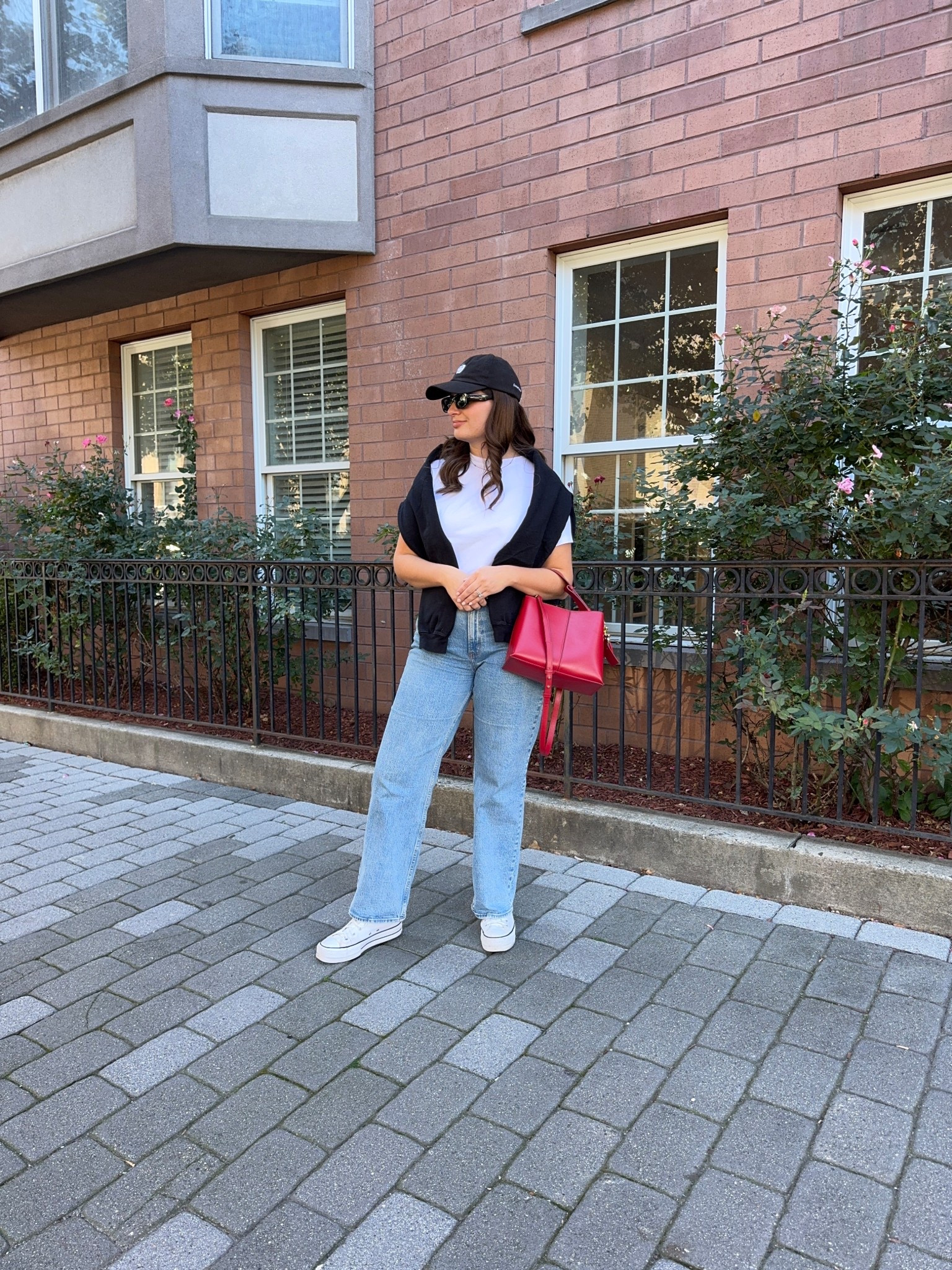 Sometimes a simple pairing of jeans and a plain white t-shirt is all you need as the base of your outfit. I draped a black sweatshirt over my shoulders for when the temperatures dropped. I added a baseball cap and my platform Converse sneakers to keep it casual but then grabbed my red purse for a bit of a statement moment. 

#LTKFindsUnder100 #LTKSeasonal #LTKStyleTip