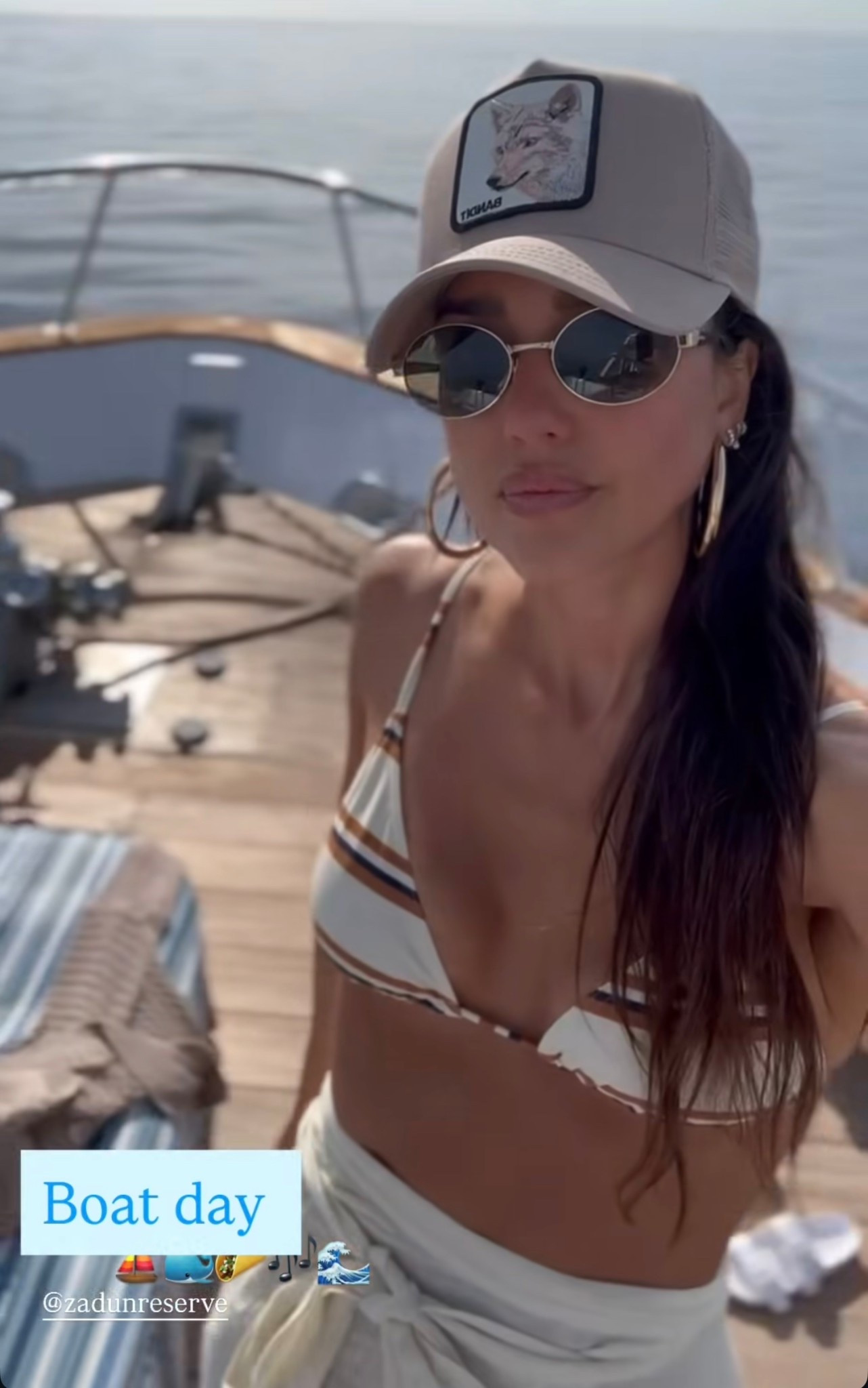 Jessica Alba's striped triangle bikini top and  striped bikini briefs, Oval Sunglasses patch trucker hat