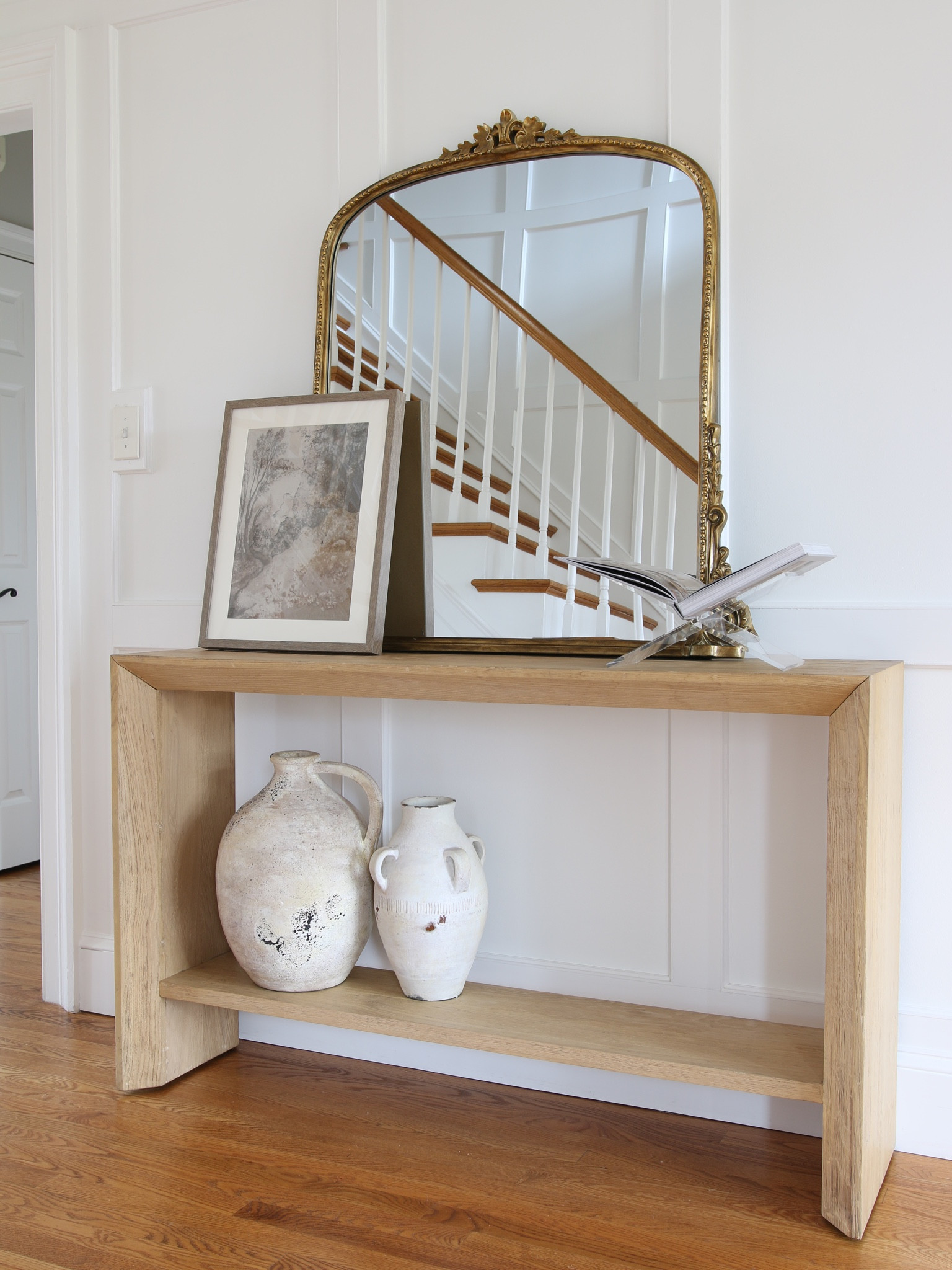 This is the space between my office doors and the hallway to closets and a bathroom. It is the perfect spot for a console table. 
This white oak console table is from Crate and Barrel.  The centerpiece of the style is the famous Anthro Gleaming Primrose mirror. I finished it with 2 artisan cases from Pottery Barn and a framed art from Target Studio McGee 

#LTKhome #LTKstyletip #LTKFind
