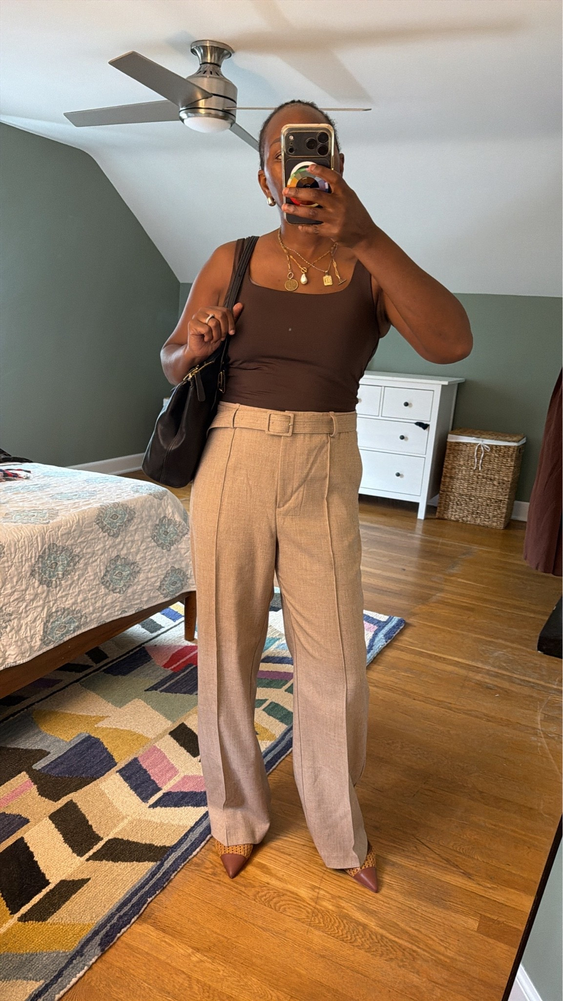 Fall workwear outfit idea. Chocolate brown square-neck bodysuit (Aritzia) styled with tan pleated trouser pants (H&M) for an easy office-to-weekend look. Adding a belted waist and gold layered necklaces to elevate a simple neutral outfit — perfect for fall transitional dressing, business casual outfits, or a capsule wardrobe staple. 
Fall outfit inspo | workwear style | neutral outfit | business casual | office outfit ideas | trouser pants outfit | Aritzia bodysuit | H&M workwear