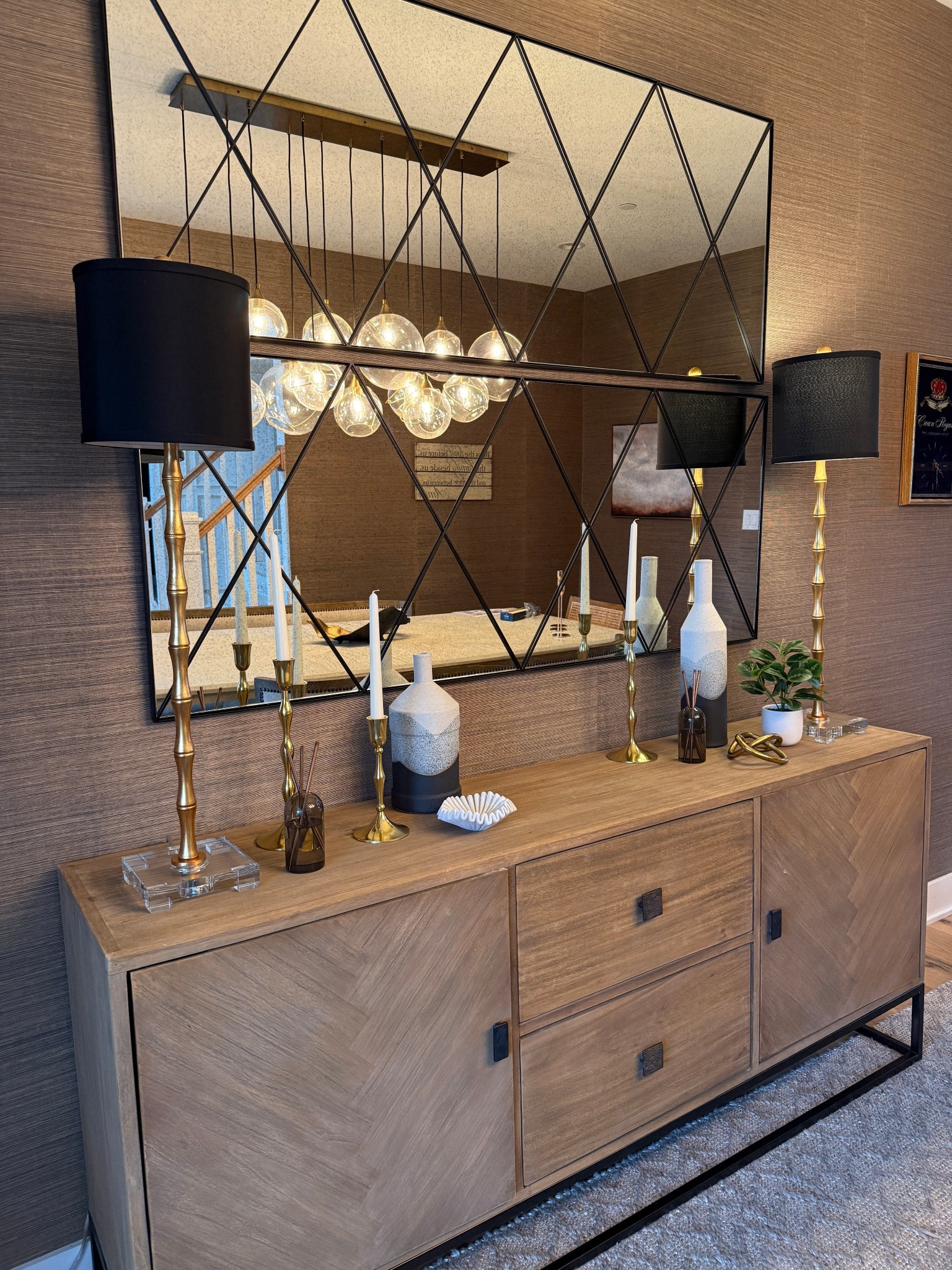 For the dining room sideboard at Warrington House, we built on our client’s existing pieces — a beautiful mirror and lamps — by adding tapered candles and vases for balance and softness. The result is a timeless, layered look that feels complete yet effortless.
