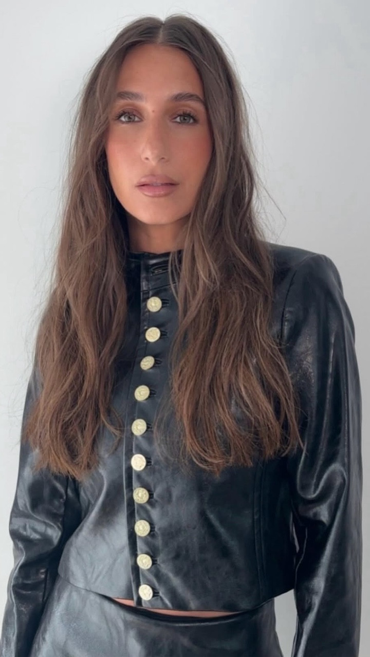 Amanda Batula wearing vegan leather cropped button front jacket and matching vegan mini skirt