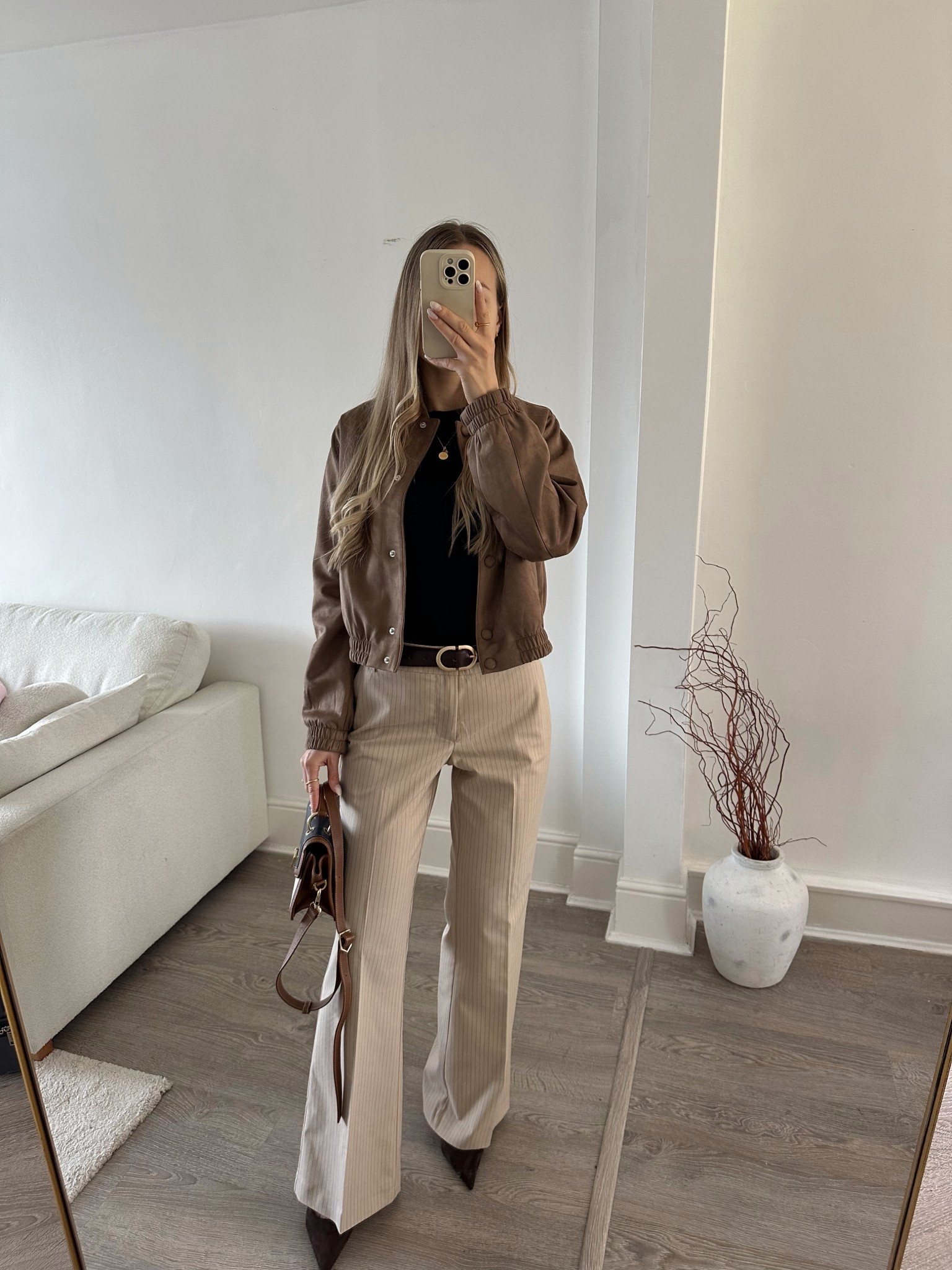 Neutral spring outfit styling a suede jacket with tailored trousers 