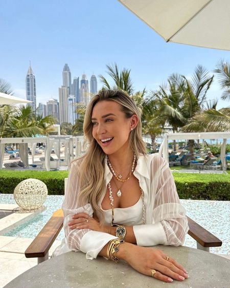 Dubai lunch look - simple white dress & sheer white over shirt styled with lots of gold jewellery & accessories

#LTKstyletip #LTKtravel #LTKSeasonal