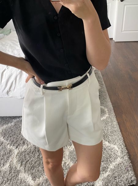 European style white shorts black belt black button down shirt 
High waisted pleated shorts - on sale for less than $20

#LTKSeasonal #LTKunder100 #LTKstyletip