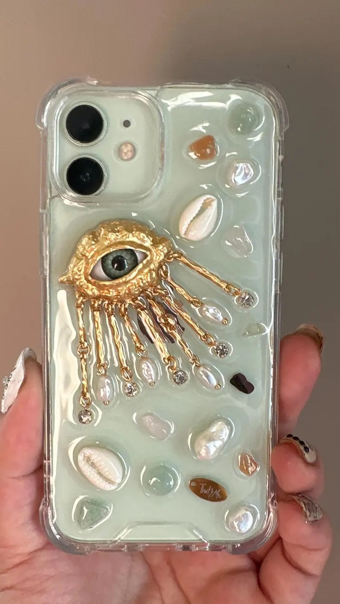 If Elsa Schiaparelli designed iPhone cases…
It would look exactly like this.
Evil eye energy, gold detailing, seashell accents — maximalist, surreal, and so chic.
Your phone just became an accessory. 📱

Designer-inspired, but make it wearable.
This evil eye iPhone case is giving surreal glamour, gold drama, and main-character energy.
Art for your phone. Protection for your vibe. 

#LTKHoliday #LTKFindsUnder50 #LTKGiftGuide
