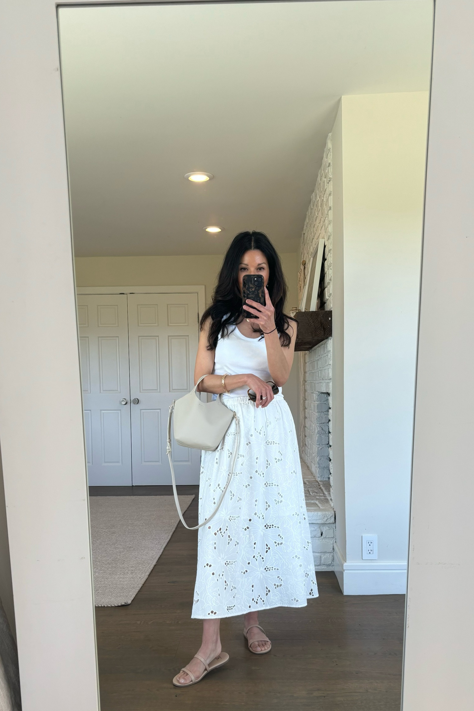 - This white tank has a built in shelf bra and it’s so convenient! I’m wearing a size small here, but I could almost go down to an XS. Runs a bit big  
- White eyelet midi skirt. I’m wearing a small  
- Beige sandals that are super affordable and comfortable. True to size. 
-  My bag is from Zara and is still available, but I can’t link Zara. 

White outfit 
Summer outfit 


#LTKOver40 #LTKSeasonal #LTKShoeCrush