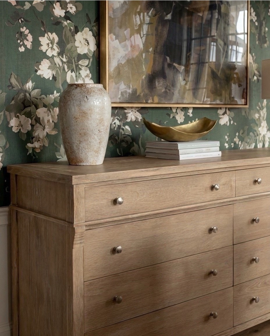 Shop the Look:
• Deep green floral wallpaper
• Marble-top dining table with fluted wood base
• Curved boucle dining chairs with brass base detail
• Light oak 6-drawer sideboard
• Matte white ceramic table lamp
• Oversized floral art in a brass frame
• Textured stone + ivory ceramic vases
• Sculptural brass decorative bowl
• Modern brass + globe chandelier
• Green vintage-style rug with cream + sage tones

#LTKHome #LTKSaleAlert