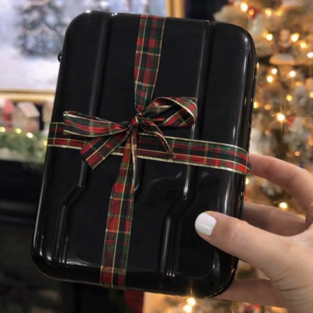 A cinematic close-up of a glossy black hard-shell suitcase wrapped in a classic red and green tartan ribbon tied into a perfect bow. Soft Christmas lights glow in the background with a blurred holiday tree, warm golden bokeh, and cozy winter ambiance. A manicured hand with white nails gently holds the suitcase, evoking luxury travel, festive gifting, and quiet holiday elegance. Shallow depth of field, soft natural lighting, refined old-money holiday aesthetic, ultra-realistic.

⸻

Hashtags (25)

#HolidayAesthetic
#LuxuryTravel
#FestiveDetails
#OldMoneyVibes
#ChristmasMood
#GiftWrapped
#TravelInStyle
#HolidayMagic
#WinterAesthetic
#QuietLuxury
#ClassicChristmas
#ChicDetails
#CozyVibes
#SeasonalStyle
#ElegantLiving
#HolidayInspo
#TravelAesthetic
#FestiveDecor
#MinimalLuxury
#ChristmasTravel
#WrappedWithLove
#WinterGlow
#TimelessStyle
#HolidayVibes
#LuxuryMoments

#LTKHoliday #LTKGiftGuide #LTKdayinmylife