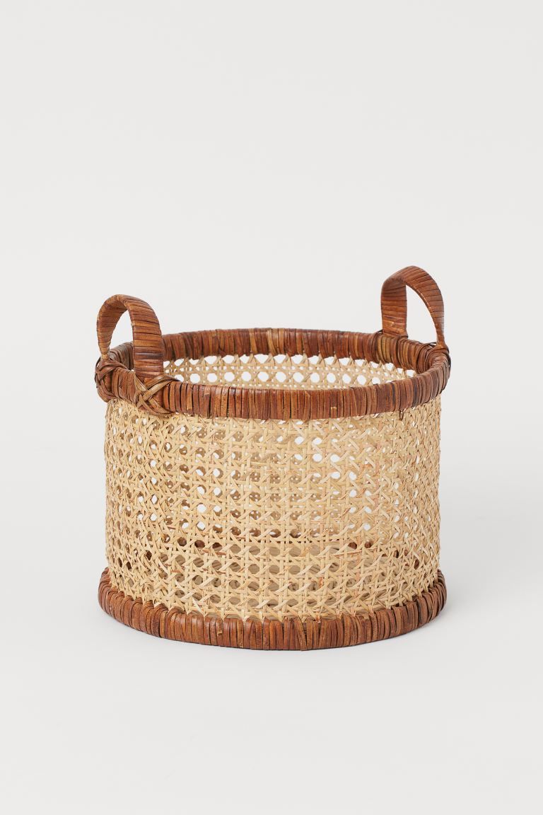 Basket in braided rattan with straw details. Two handles at top. Diameter 10 1/2 in. Height 7 3/4... | H&M (US + CA)