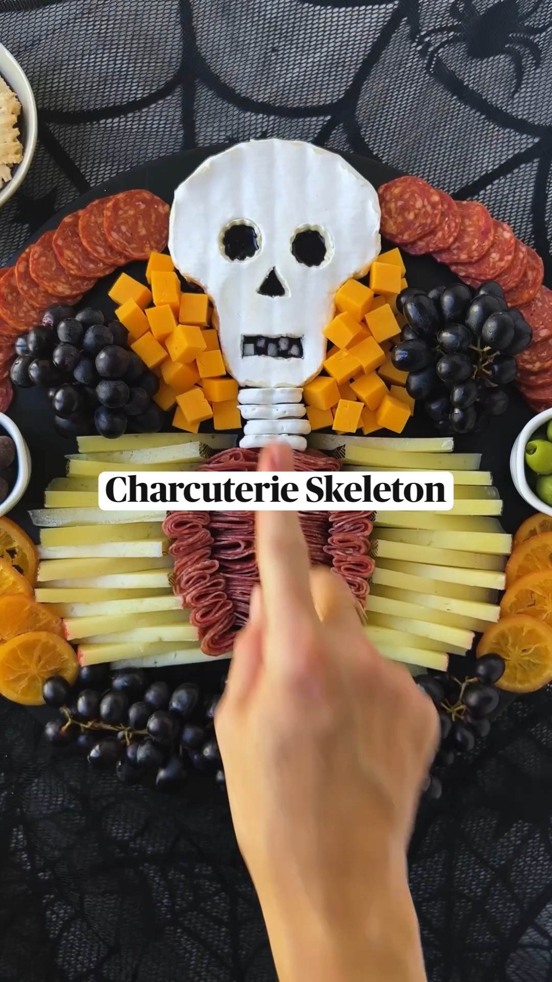 INGREDIENTS 
* 13 oz brie 
* 2 oz blueberry jam 
* 4 yogurt covered pretzels 
* string cheese
* 16 oz young manchego, sliced evenly lengthwise & height wise into triangles
* 12 oz @columbusmeats Italian Dry Salame 
* @columbusmeats Charcuterie Tasting Board (I used the Calabrese Salame, Castelvetrano olives & chocolate covered cranberries from here)
* 10 oz mild cheddar, cubed 
* 30 oz dark purple grapes 
* 8 dried orange slices 
  
INSTRUCTIONS 
1. Place brie in the freezer for 15-20 minutes to allow for easier cutting. 
2. For the brie skull, cut wedges out of the sides of the bottom third of the cheese (to make a mushroom-like shape), then carefully slice the brie in half. 
3. Using the top half of the brie, use a paring knife to cut out a rectangle for the mouth, a triangle for the nose and circles for both eyes. NOTE: suggest using a small round cookie cutter for the eyes. 
4. Use one slice of the manchego to create 5 small square “teeth” to be placed in the mouth after step 5. 
5. Dollop blueberry jam on bottom half of brie, then cover with the top half of the brie. 
6. Place the manchego teeth in the mouth. 
7. Once the skull is assembled, trim and perfect any edges of the skull before placing at the top of your board. NOTE: I took some of the sides off to make it narrower.  
8. Place the yogurt covered pretzels under the brie skull to create a neck, then place string cheese directly under that. 
9. On each side of the string cheese, layer manchego slices (alternating triangles) into a crescent shape to create the ribcage. 
10. Fold the Italian Dry Salame into quarters and line inside of the “manchego ribcage.” 
11. line the top edges of the board with Calabrese Salame. Then, fill a ramekin with Castelvetrano olives and another ramekin with chocolate cranberries and place on each side of the board.
12. Decorate the rest of the board with cheddar cubes, grapes and dried oranges. Enjoy!

#LTKSeasonal #LTKHome #LTKFindsUnder100