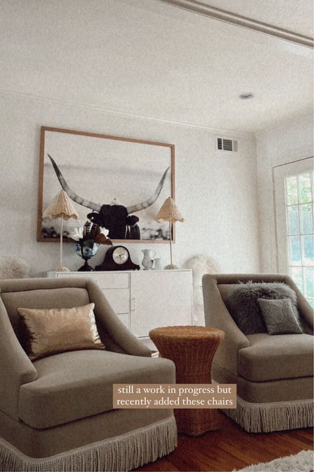 Ashley Butterfield of SideSmile Style shares a sneak peek of her living room featuring velvet fringe trim club chairs and rattan lamps. 

#LTKhome #LTKFind #LTKstyletip
