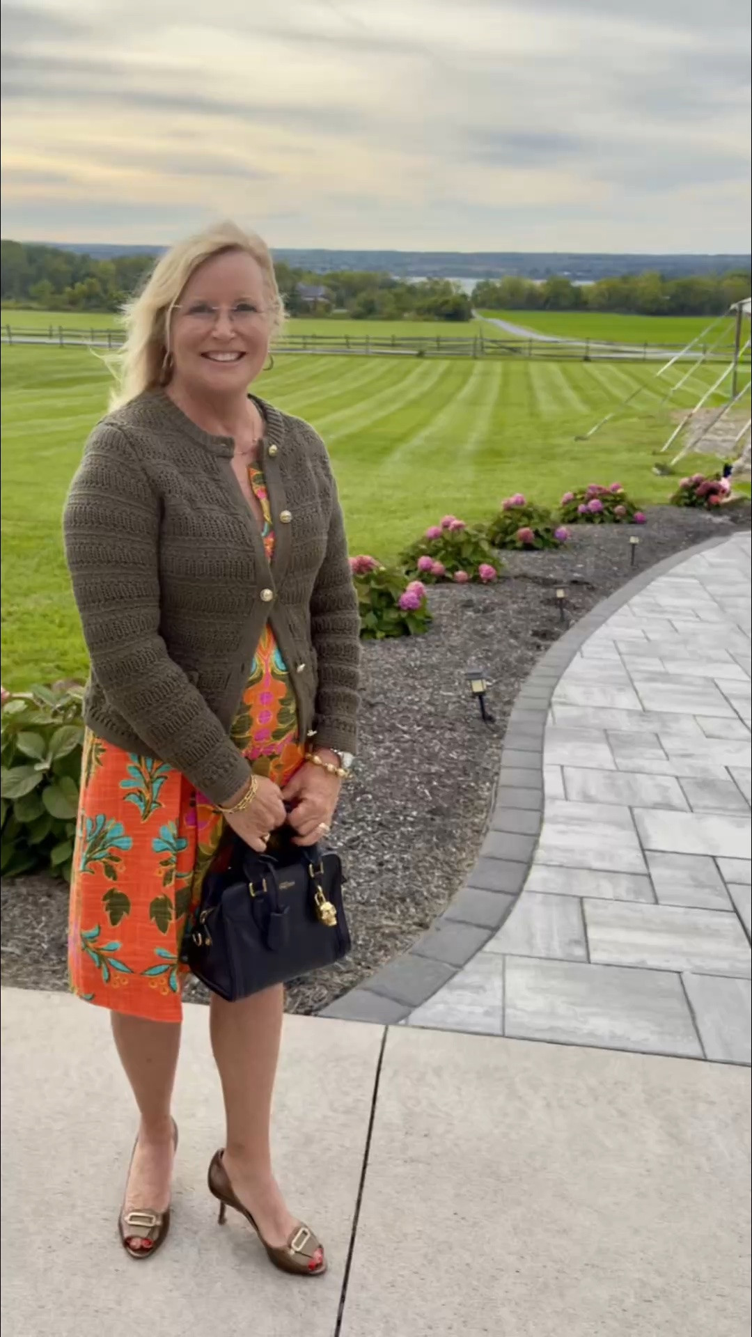 Fall wedding guest attire is all about balancing chic style with the unpredictable elements! 🍂✨

It was definitely on the chilly and windy side, so this look was all about clever layering without losing that elevated feel. I paired this vibrant orange sleeveless dress with a cozy olive sweater draped over top—the perfect color contrast for the season. To keep things polished, I finished the look with bronze heels and my favorite convertible crossbody top handle purse that takes me from ceremony to reception effortlessly.

Shop this look via the links below:

#fallwedding #weddingguestoutfit #weddinggueststyle #fallfashion #ootd #ltkwedding

#LTKOver40 #LTKWedding #LTKTravel