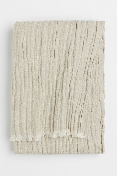 Conscious choice  Crinkled throw in a soft, woven linen and cotton blend with raw fringe at sides... | H&M (US + CA)