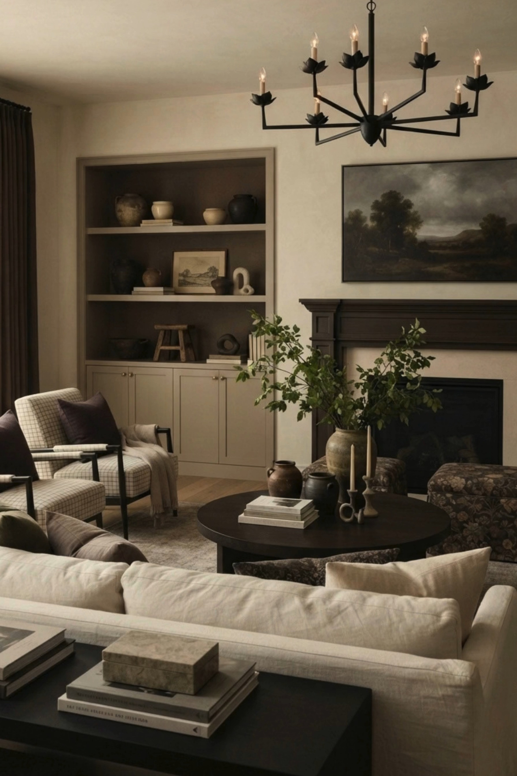 Moody Neutral Living Room 🤎 This elevated living room blends modern traditional style, English country inspiration, and warm neutral decor for a timeless, collected feel. A dark wood fireplace mantel and dramatic landscape artwork create a striking focal point, while built-in shelving, creamy linen seating, plaid accent chairs, floral ottomans, a round dark wood coffee table, layered pottery, and organic greenery add texture and character. The black statement chandelier, earthy brown tones, vintage-inspired accents, and cozy textiles give this space a sophisticated designer look that feels warm and inviting.

🖤 If you want to see more content like this, FOLLOW maeveandmodern on LTK, Instagram, and Pinterest! Check out our blog where we post daily, maeveandmodern.com!

Moody Neutral Living Room | Living Room Inspiration | Modern Traditional Living Room | English Country Decor | Transitional Living Room | Warm Neutral Decor | Dark Wood Fireplace | Fireplace Mantel Ideas | Landscape Wall Art | Built In Shelves | Built In Cabinetry | Cream Sofa | Linen Sofa | Plaid Accent Chairs | Floral Ottoman | Round Coffee Table | Dark Wood Coffee Table | Black Chandelier | Statement Lighting | Vintage Inspired Decor | Collected Interiors | Neutral Area Rug | Organic Greenery | Pottery Decor | Coffee Table Styling | Cozy Living Room | Earth Tone Decor | Designer Living Room | Timeless Interior Design | Fall Home Inspiration

#LTKHome #LTKSaleAlert #LTKSeasonal
