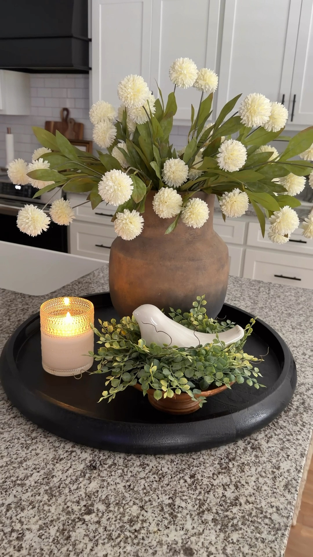 Okay…these pom stems got me. They have that soft, neutral look that are so realistic__and you know I’m picky about my stems.

I tucked them into this ombré vase (which just so happens to be on sale right now 👀), and it all came together so easily. 

I also added a little height with a wood pedestal, set a candle ring on top for my bird (because she needed her moment), and finished it with my go-to flameless candle for that cozy glow. 🥰