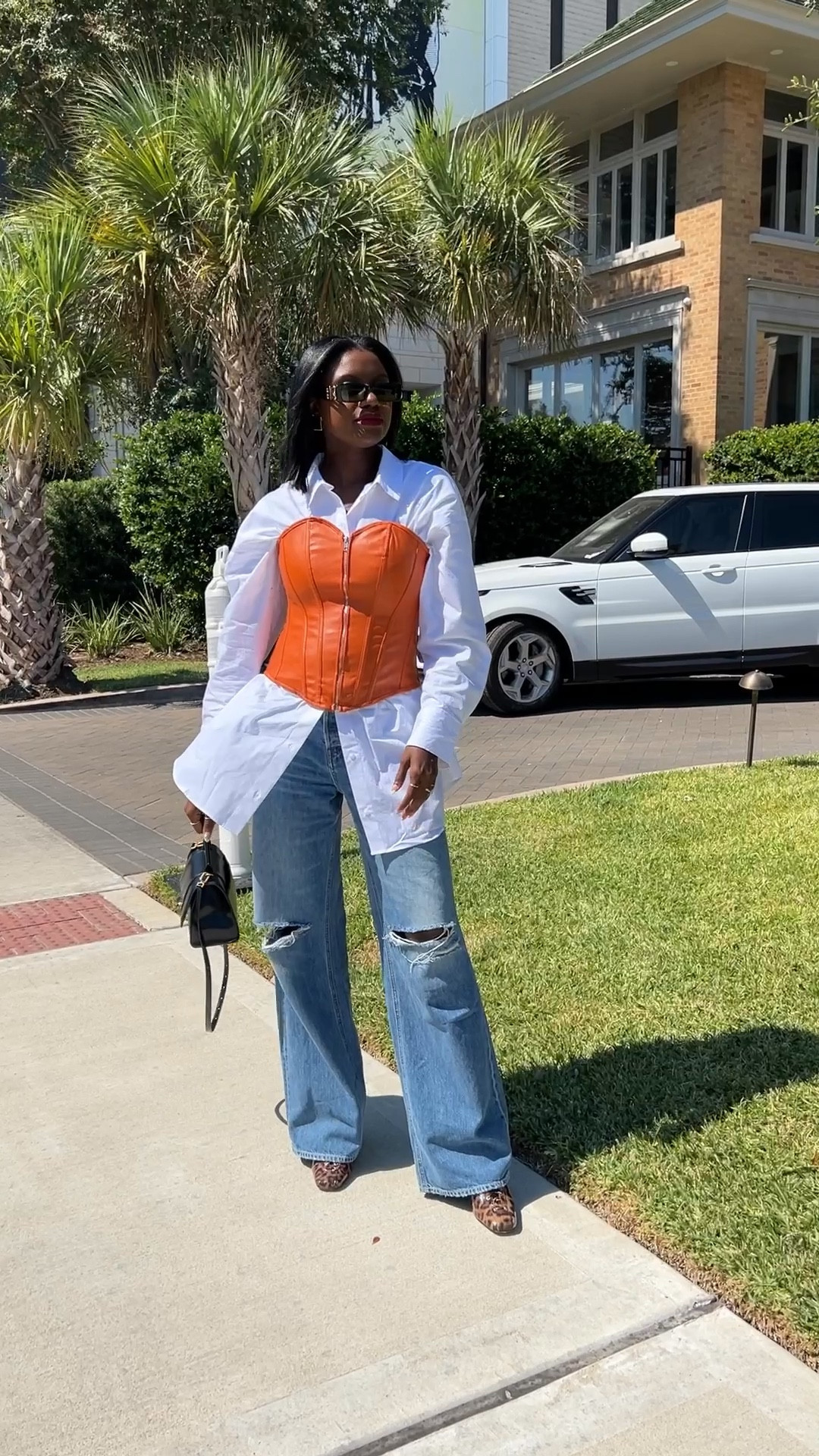How to style an oversized button up shirt! I layered it with a fall orange corset, wide leg loose denim and leopard print boot. My classic Balenciaga hour glass bag and black sunglasses are the final piece  

#LTKHalloween #LTKstyletip #LTKunder100
