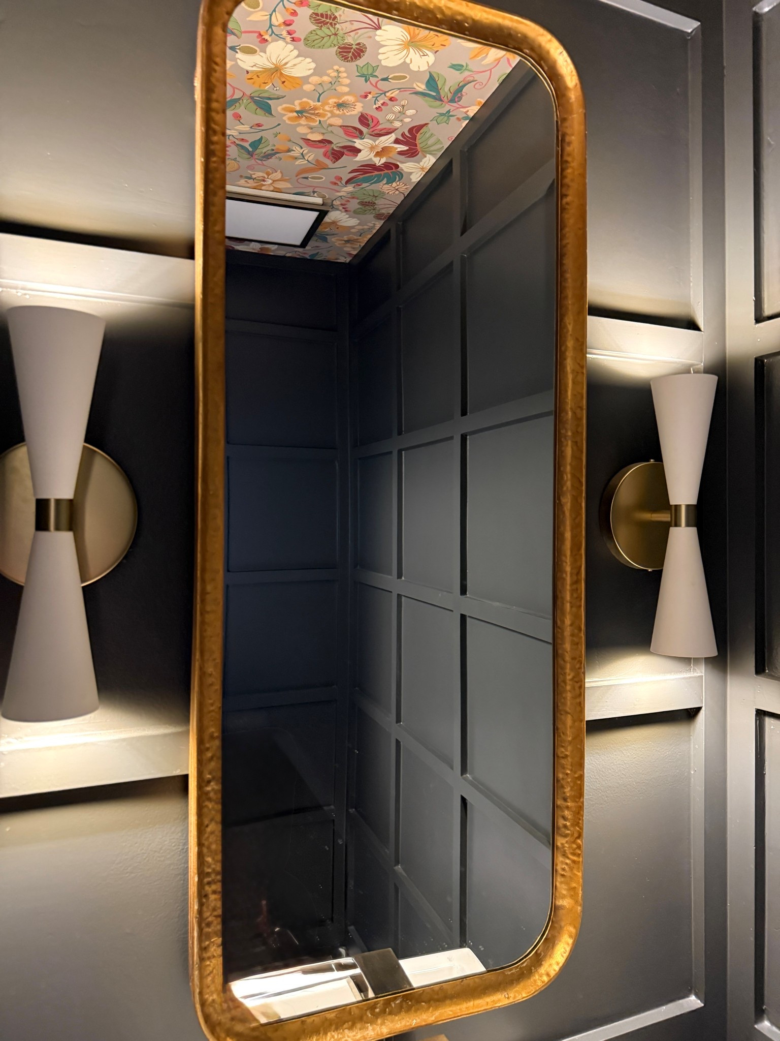 Just your friendly reminder that you can have it all even in a small space. This powder room is colored drenched in #SWironore Has wallpaper on the 5th wall (ceiling), millwork, brushed brass fixtures, and a hammered mirror. You can go big as long as it stays cohesive. A moody, sophisticated powder room will never go out of style. This bathroom might be a few years old but the sconces are still available. #timelessdesign #moodypowderroom #blackbathroom #wallpaperceiling #ltkshop #ltkhome 

#LTKHome #LTKStyleTip