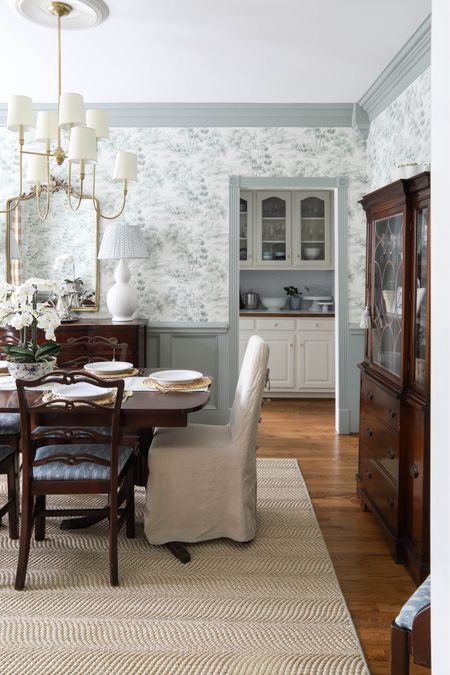 My dining room is colorful and traditional with antique furniture, green trim and wainscoting and toile green wallpaper! The brass accents and blue textiles coordinate perfectly with the blue and white butler’s pantry beyond the room. 

#LTKhome