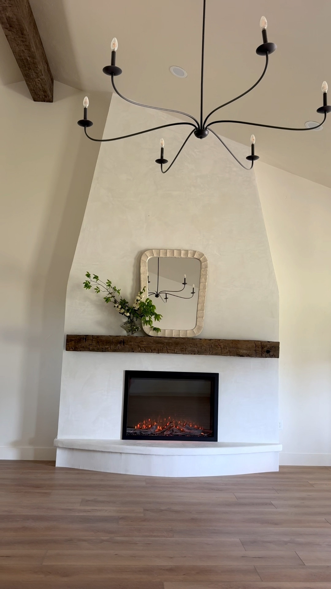 The flip house fireplace is finished!!! We used micro cement as the material. My beam is an old barn beam. I go to local reclaimed lumber yards and pick out an old beam and bring it home and hang! It’s hand sewn so it has so much character!! I linked the mantel decor, flooring, chandelier and electric fireplace insert here! The greenery is real  

#LTKSeasonal #LTKHome