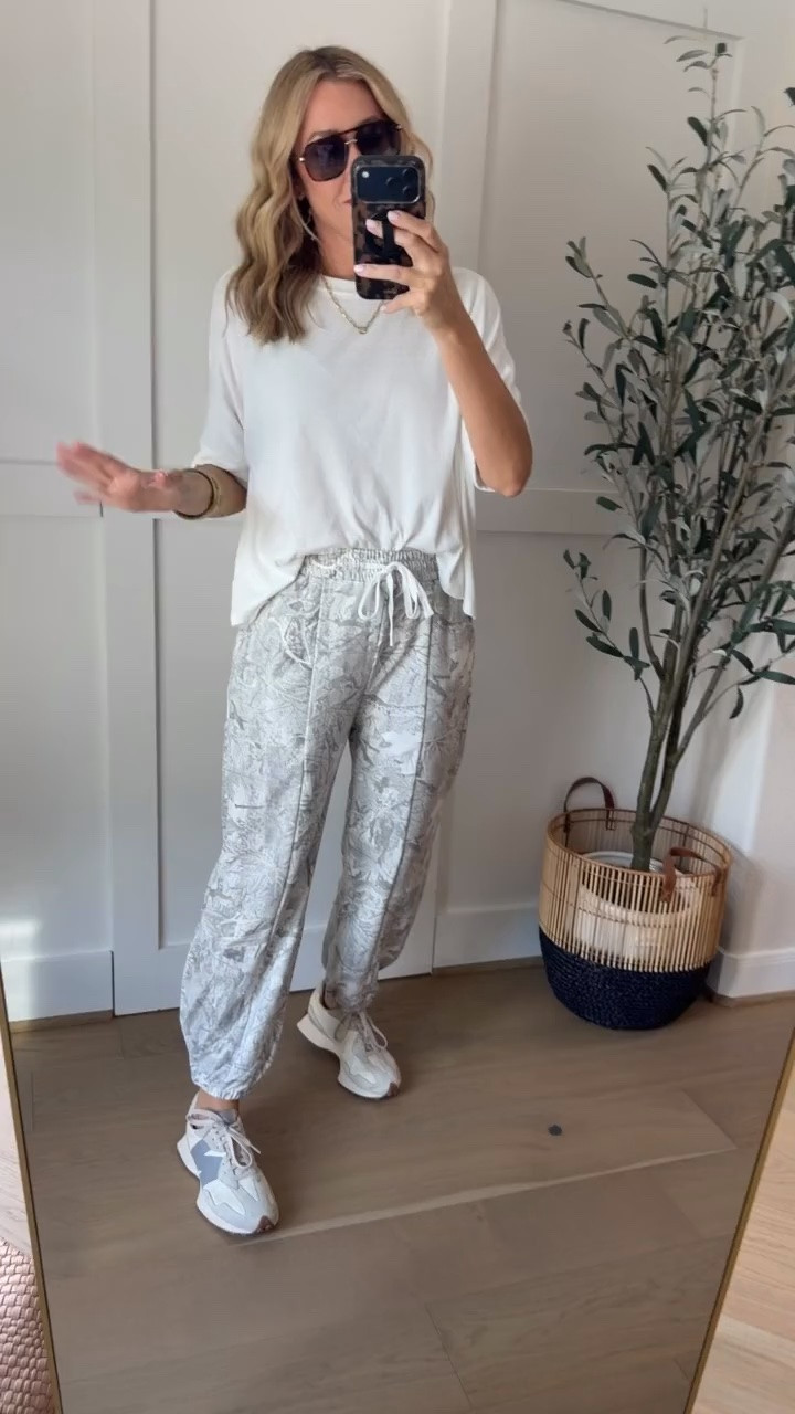 These printed joggers are a fun alternative to plain lounge pants! I love the soft gray and white floral pattern, relaxed fit, and drawstring waist. Paired with an oversized white tee and neutral sneakers, they're perfect for running errands, traveling, or those days when you want to be comfortable but still look cute.
printed joggers, floral jogger pants, gray and white pants, casual lounge pants, drawstring pants, relaxed fit joggers, comfortable travel outfit, casual fall outfit, white oversized tee, sneakers outfit, women over 40 fashion, everyday casual style, HauteandHumid
