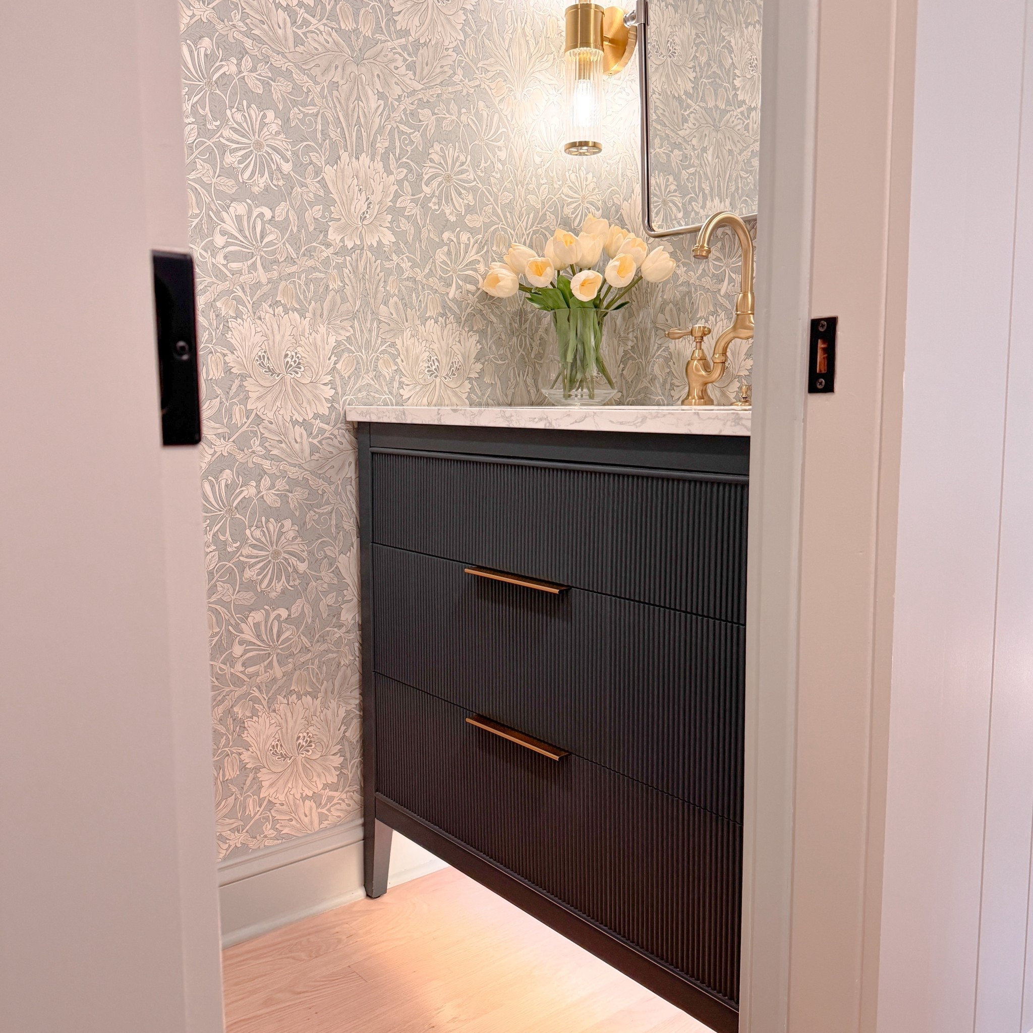 Bathroom Vanity. Beautiful floral wallpaper. Brass faucet. Brass sconce. Tulips. Vanity mirror. 

#LTKSaleAlert #LTKHome #LTKFamily