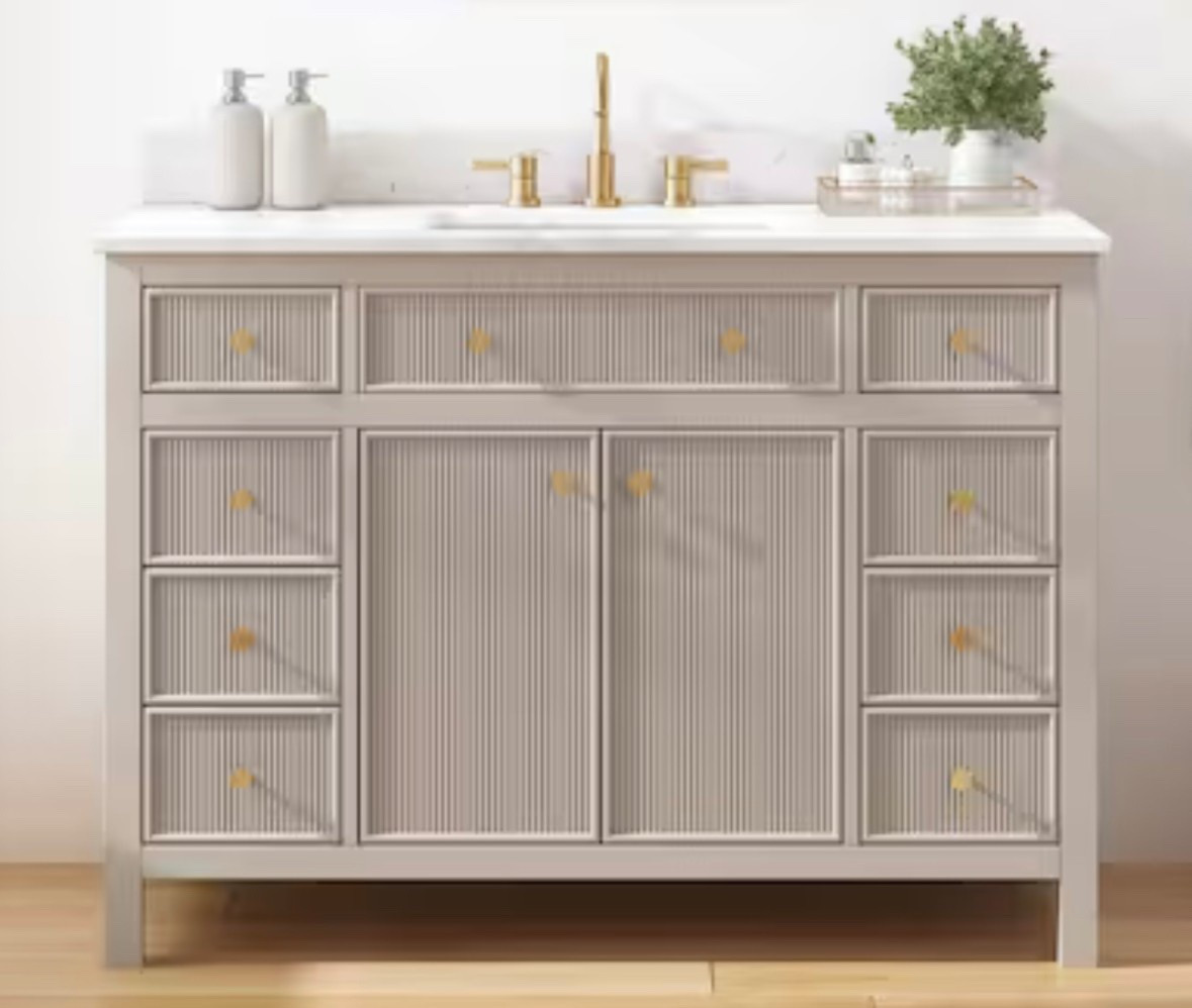 This greige fluted vanity with gold accents and a stone top is a beautiful modern addition to any bathroom. 

#LTKHome