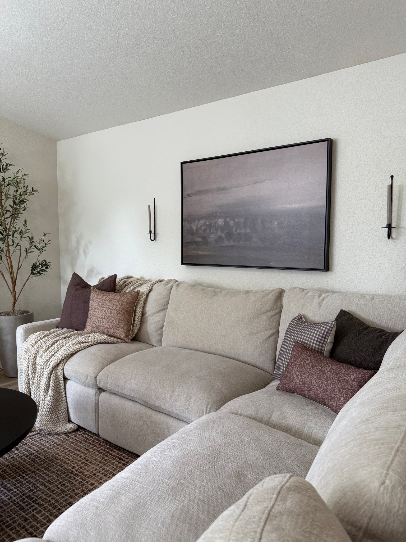 Cozy moody living room🤍 this print is the perfect addition to our living room! I love the moody abstract print and floating black frame. Balanced with these candle sconces😍 

•
•
Living room, moody art, neutral art, canvas art, living spaces sectional, deep seat, large couch, L sectional, pillow covers, sconces, olive tree, knit blanket, coffee table, family room, comfy couch, woven nook, neutral pillow, throw pillow, decorative pillows 

#LTKSeasonal #LTKHome #LTKSaleAlert