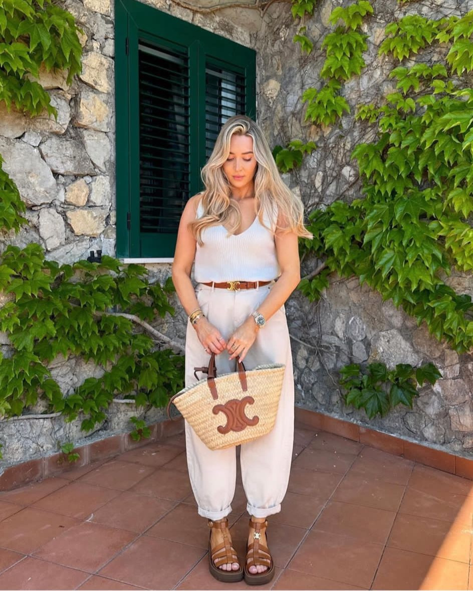 Cream & tan positano summer holiday outfit. White knit vest top, cream balloon jeans, Celine tan triomphe belt, teen triomphe basket bag & chunky gladiator sandals. Alternatives linked!

#LTKstyletip #LTKitbag #LTKshoecrush