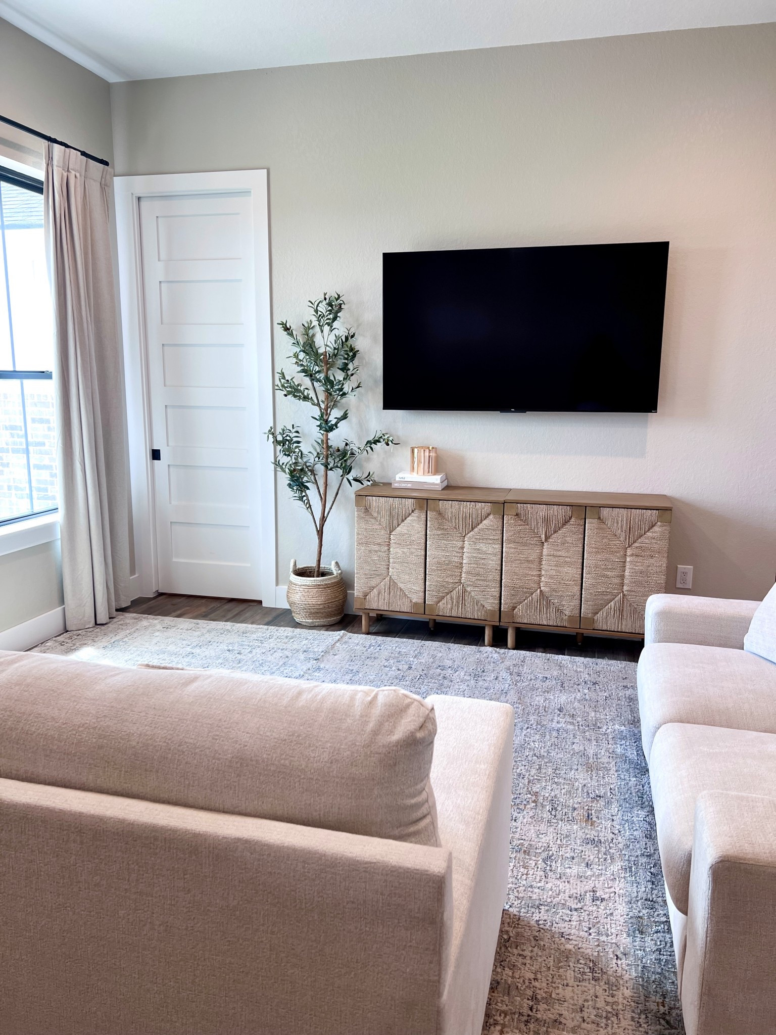 Neutral home decor for a smaller home. (1650 square feet) Neutral area rug, white couch and white love seat, olive tree, neutral entertainment console, neutral living room 

#LTKHome