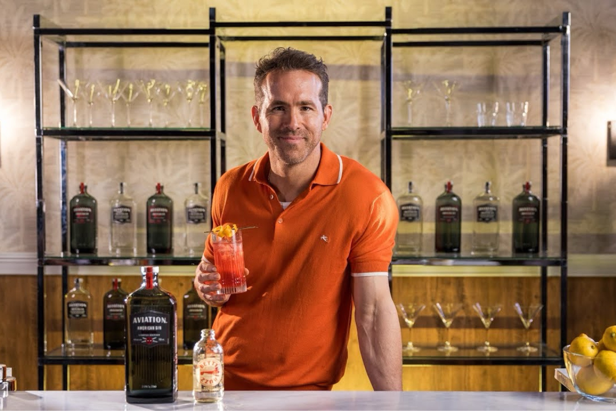 Ryan Reynolds making an Aviation Gin Vasectomy cocktail in an Etro logo embroidered orange short-sleeved polo shirt.

#LTKStyleTip #LTKMens #LTKSaleAlert